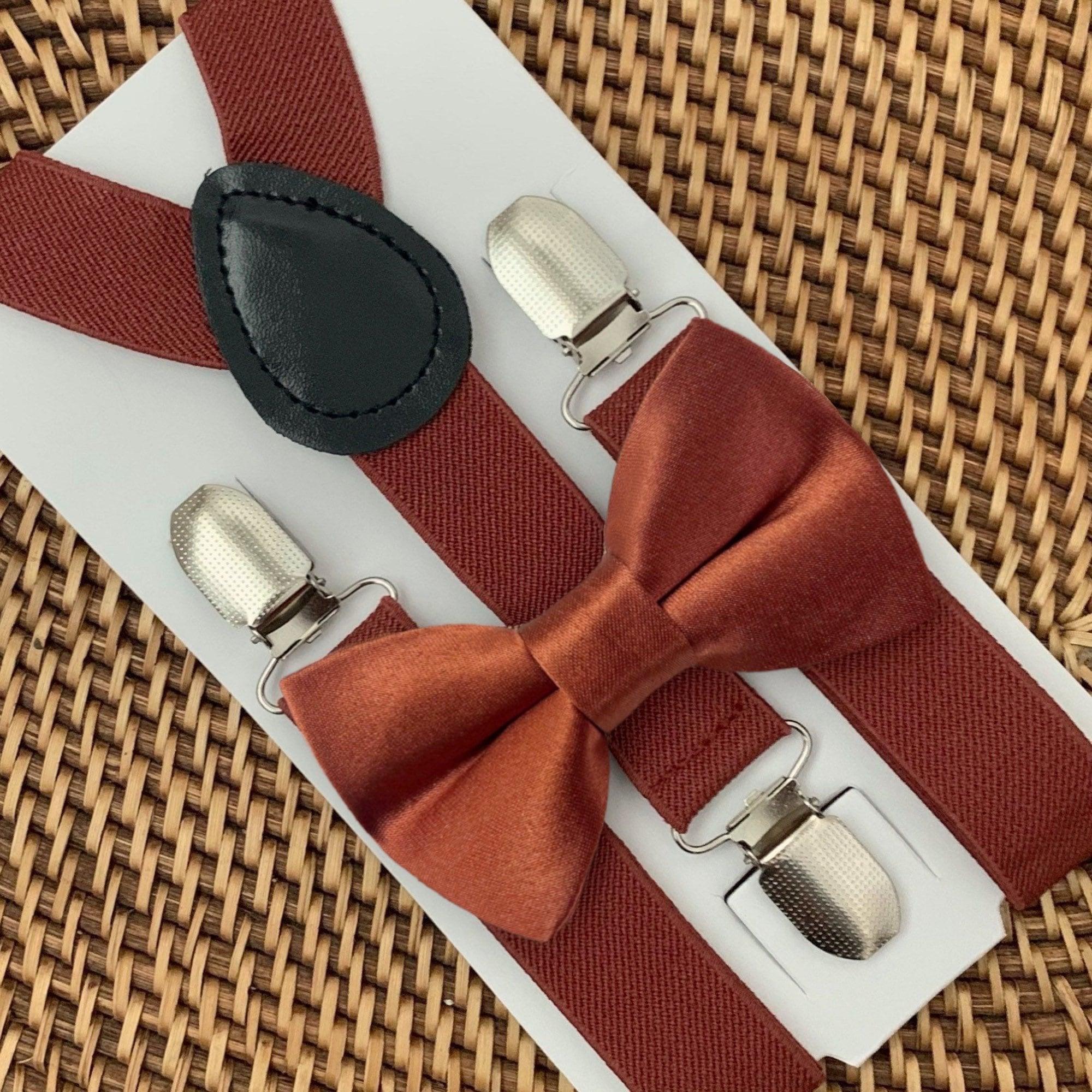 A set of terracotta colored bow tie and suspenders for adults and children,, displayed on a white background.