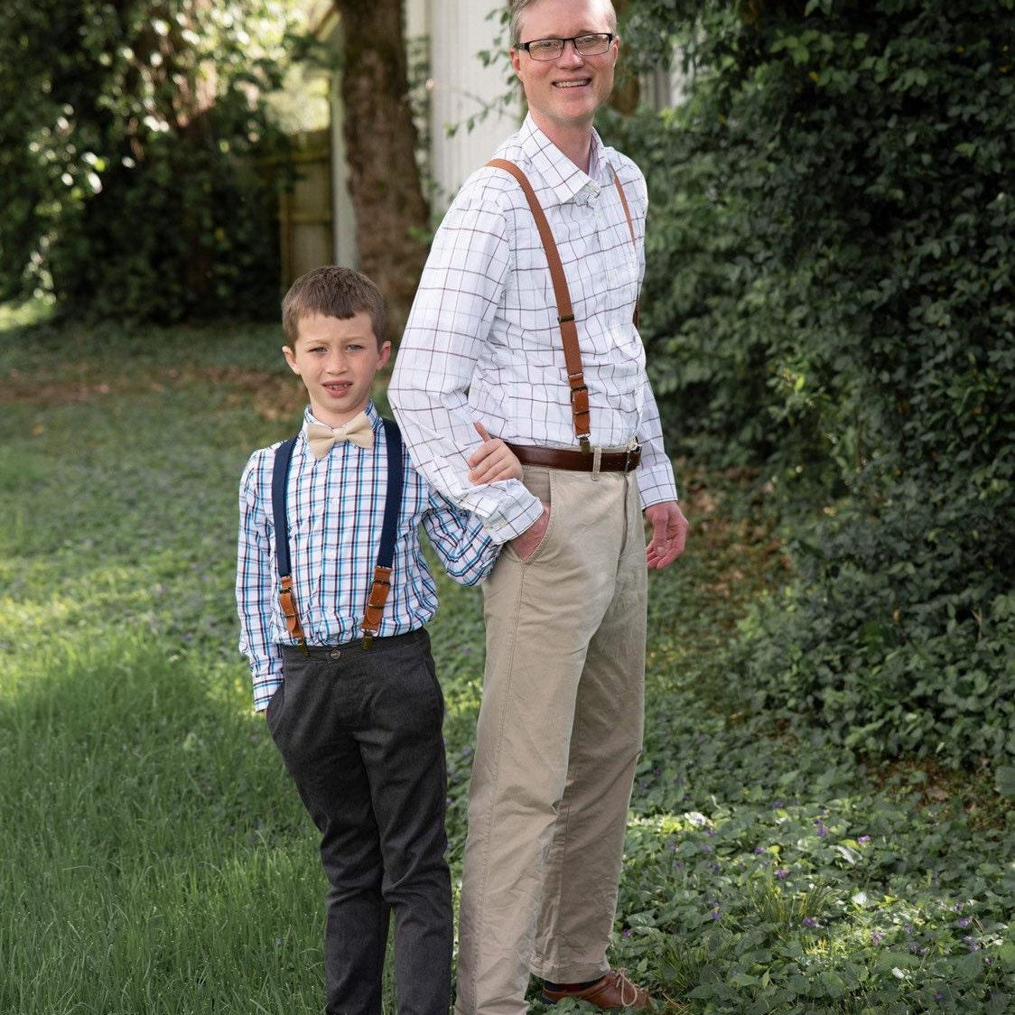 Groomsman and ring bearer in navy and brown suspenders.