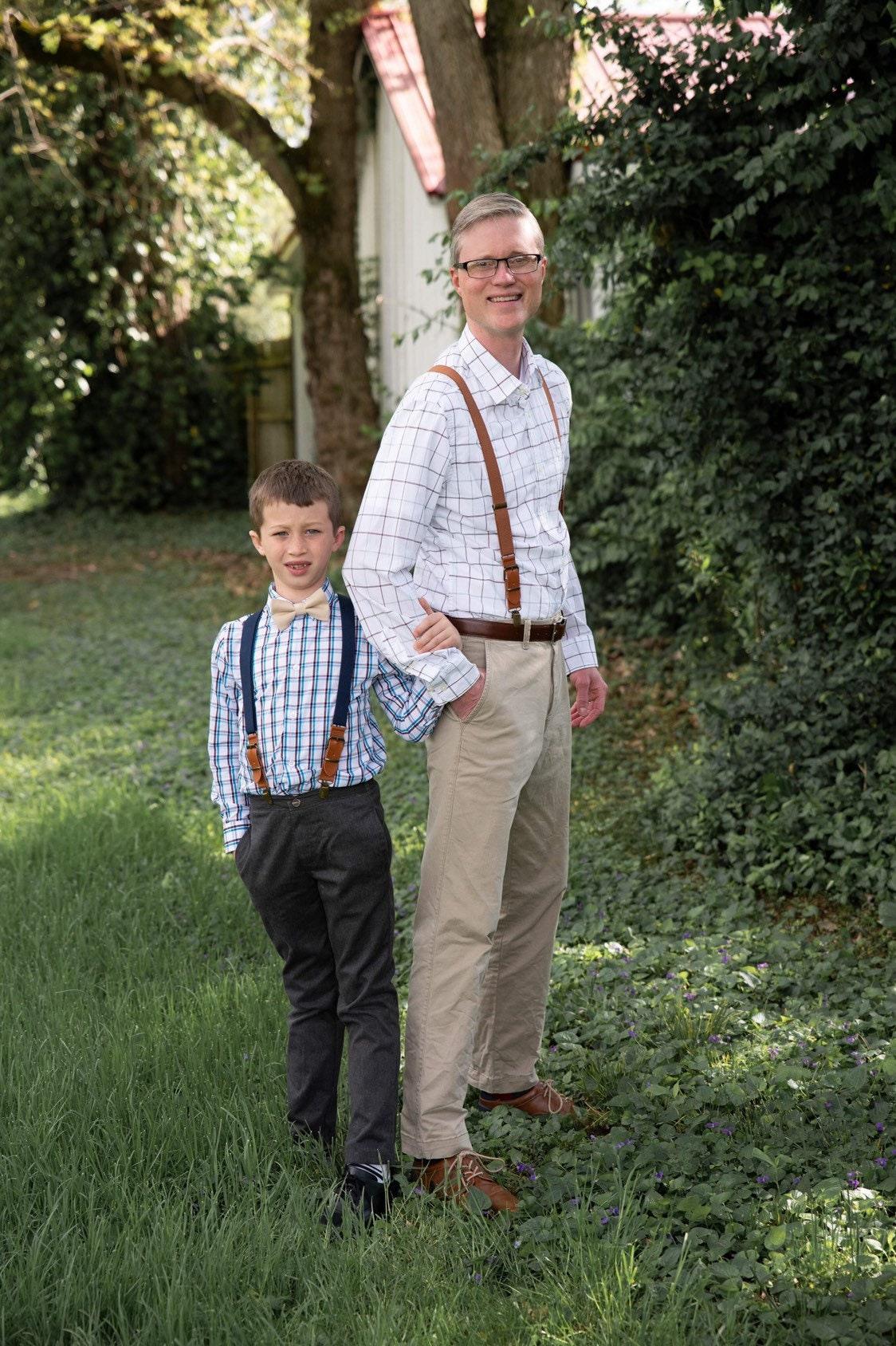 Groomsman and ring bearer in navy and brown suspenders.