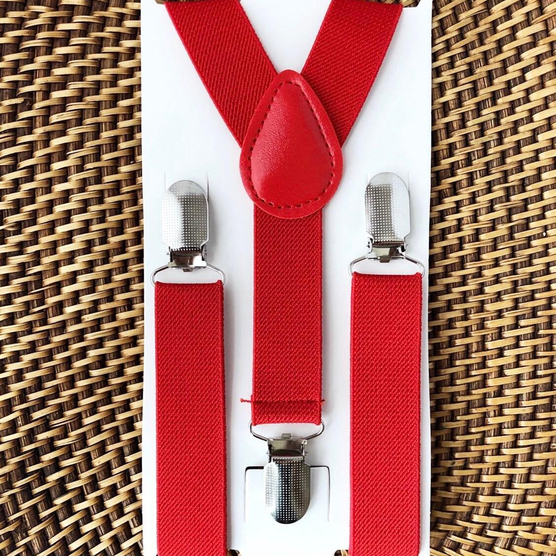 Red suspenders with silver clips for Christmas and Weddings on a white card against a woven background
