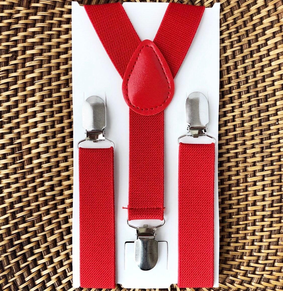 Red suspenders with silver clips for Christmas and Weddings on a white card against a woven background