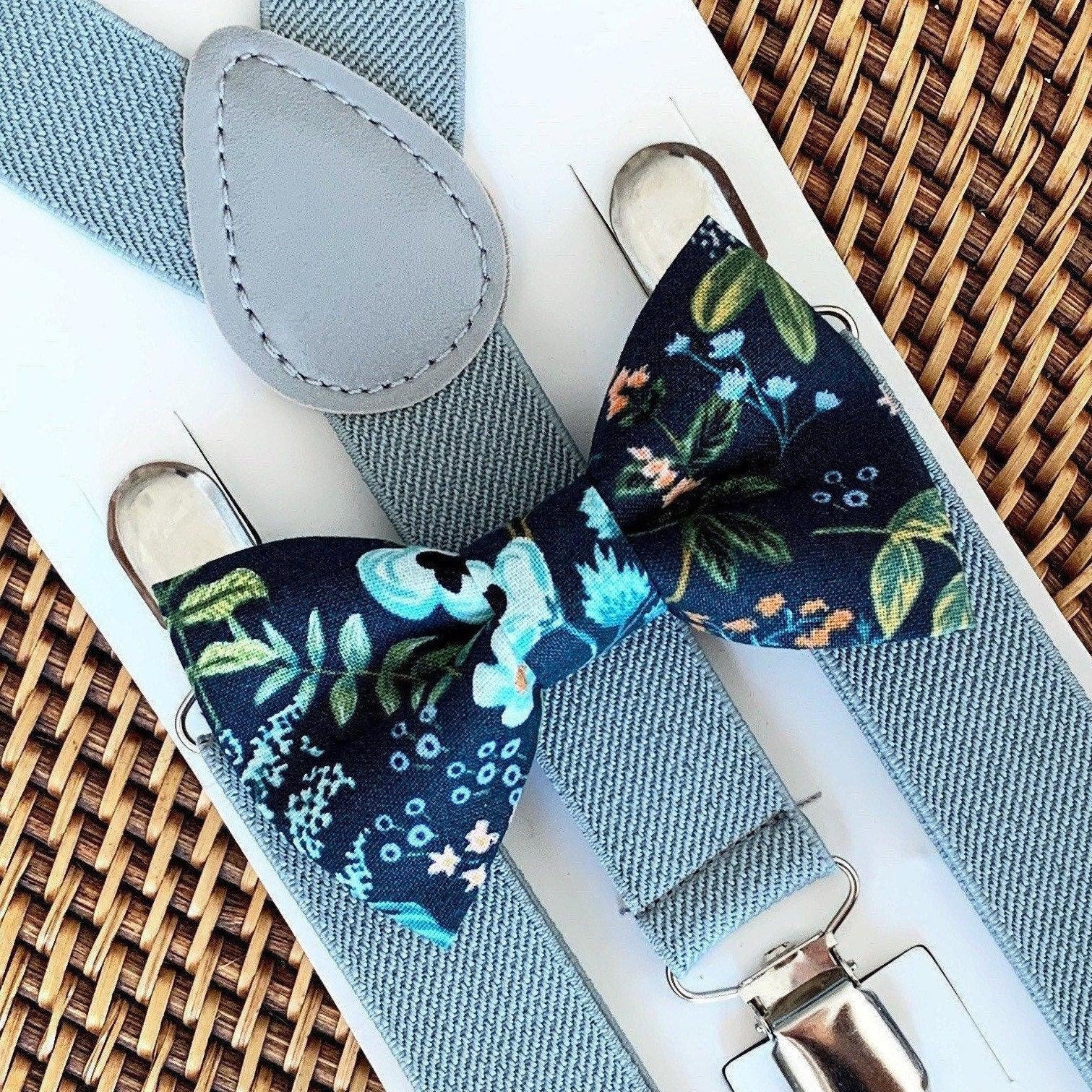 Navy floral bow tie with suspenders on a woven surface