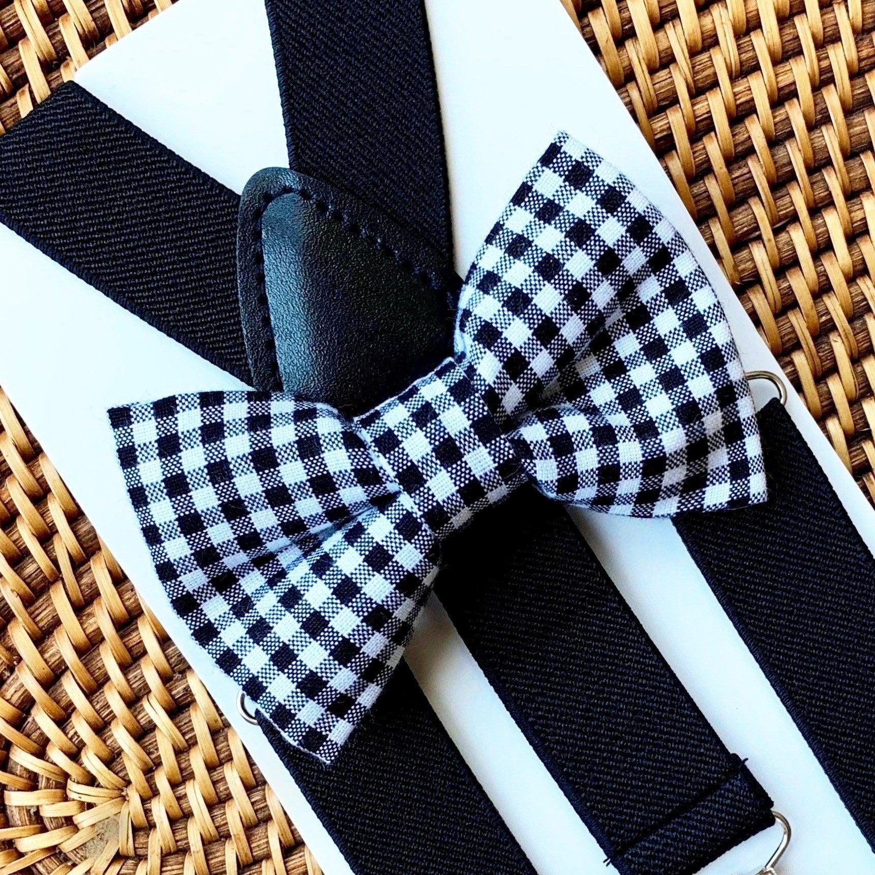 Black and white checkered bow tie with suspenders on a woven surface