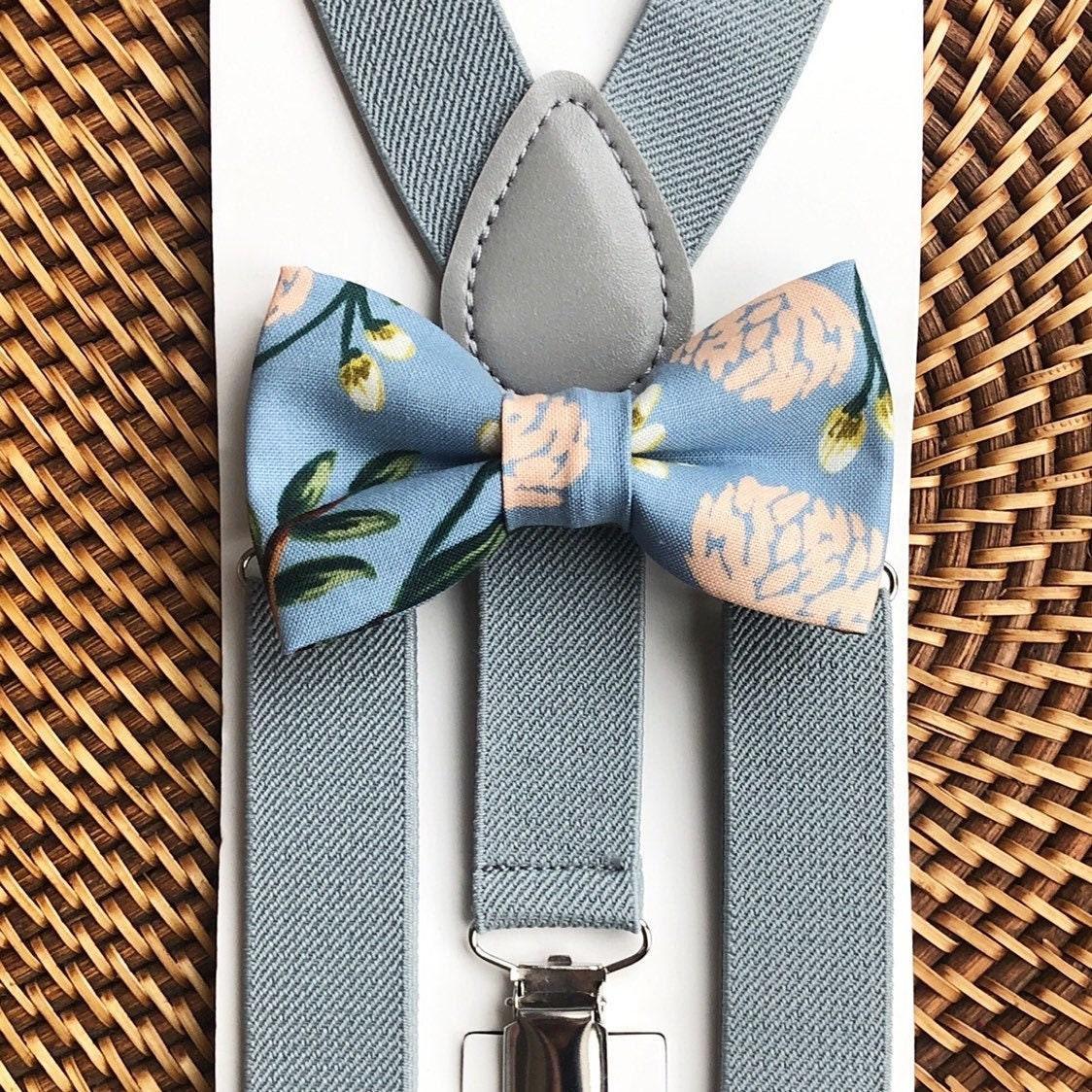 Gray suspenders with a floral bow tie on a woven background