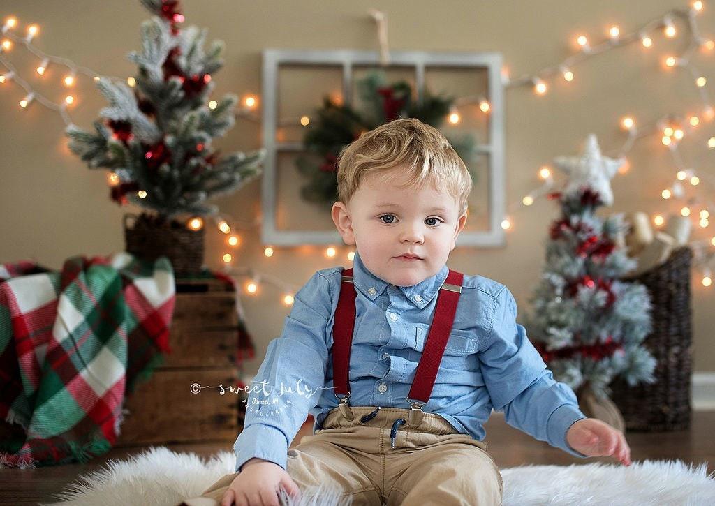Toddler in burgundy suspenders for Christmas pictures.