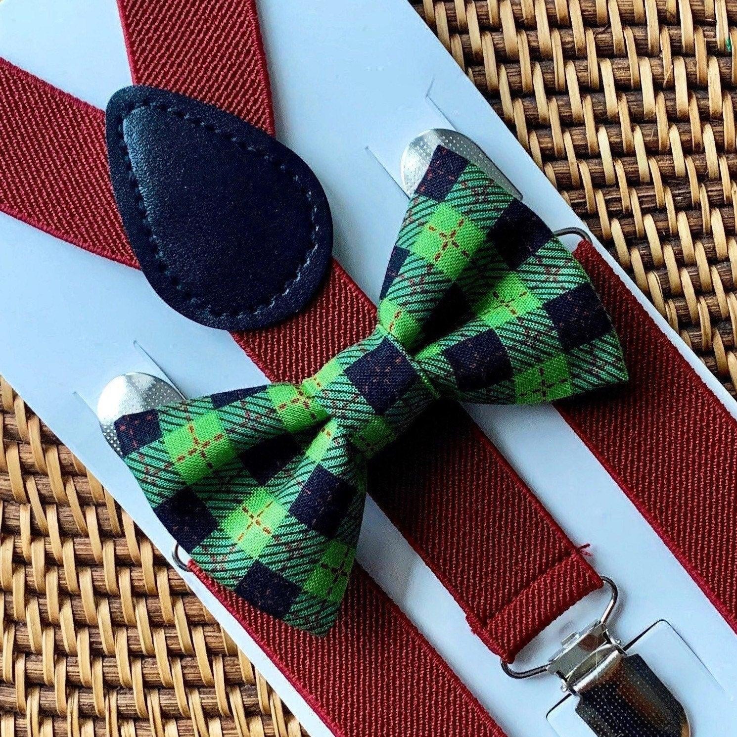 Green plaid bow tie with burgundy suspenders displayed on a white card against a woven background