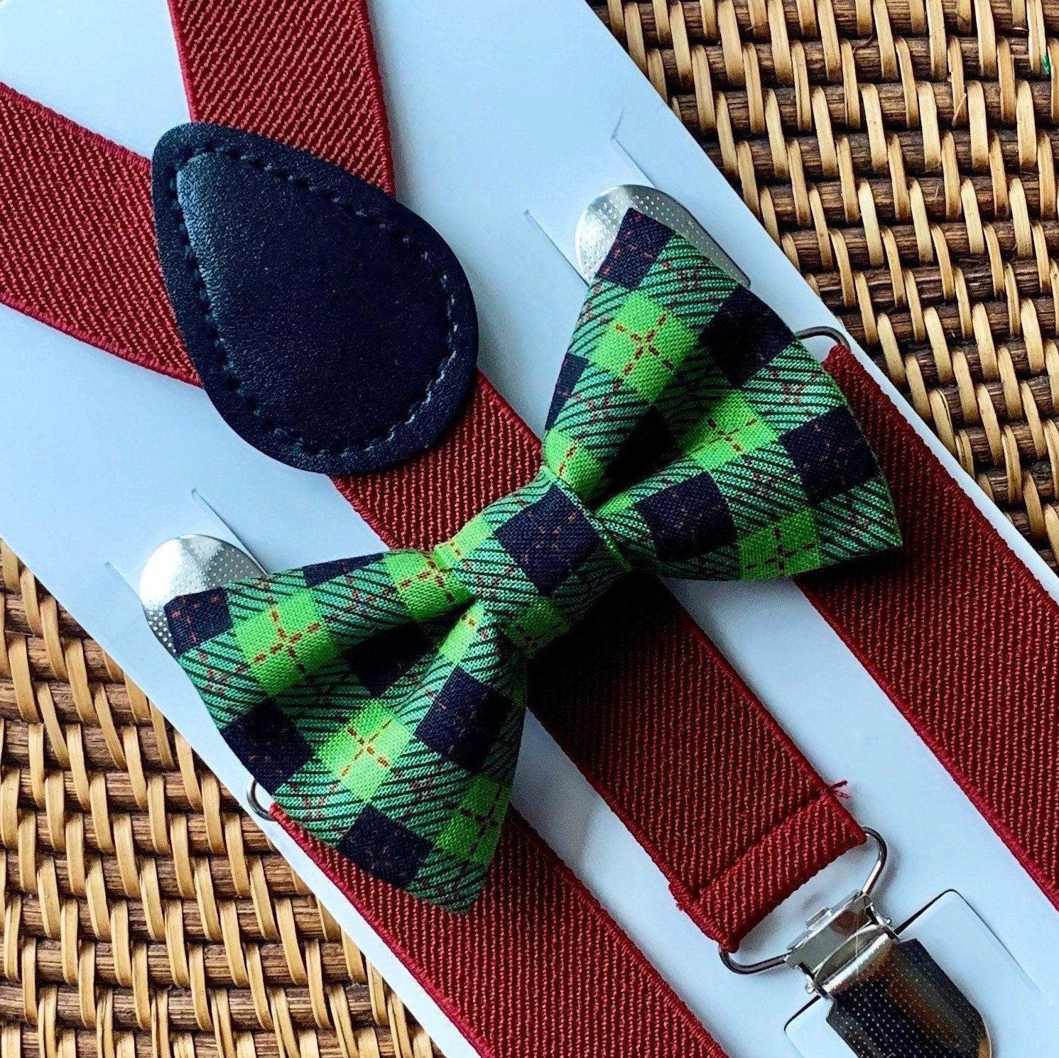 Green plaid bow tie with burgundy suspenders displayed on a white card against a woven background