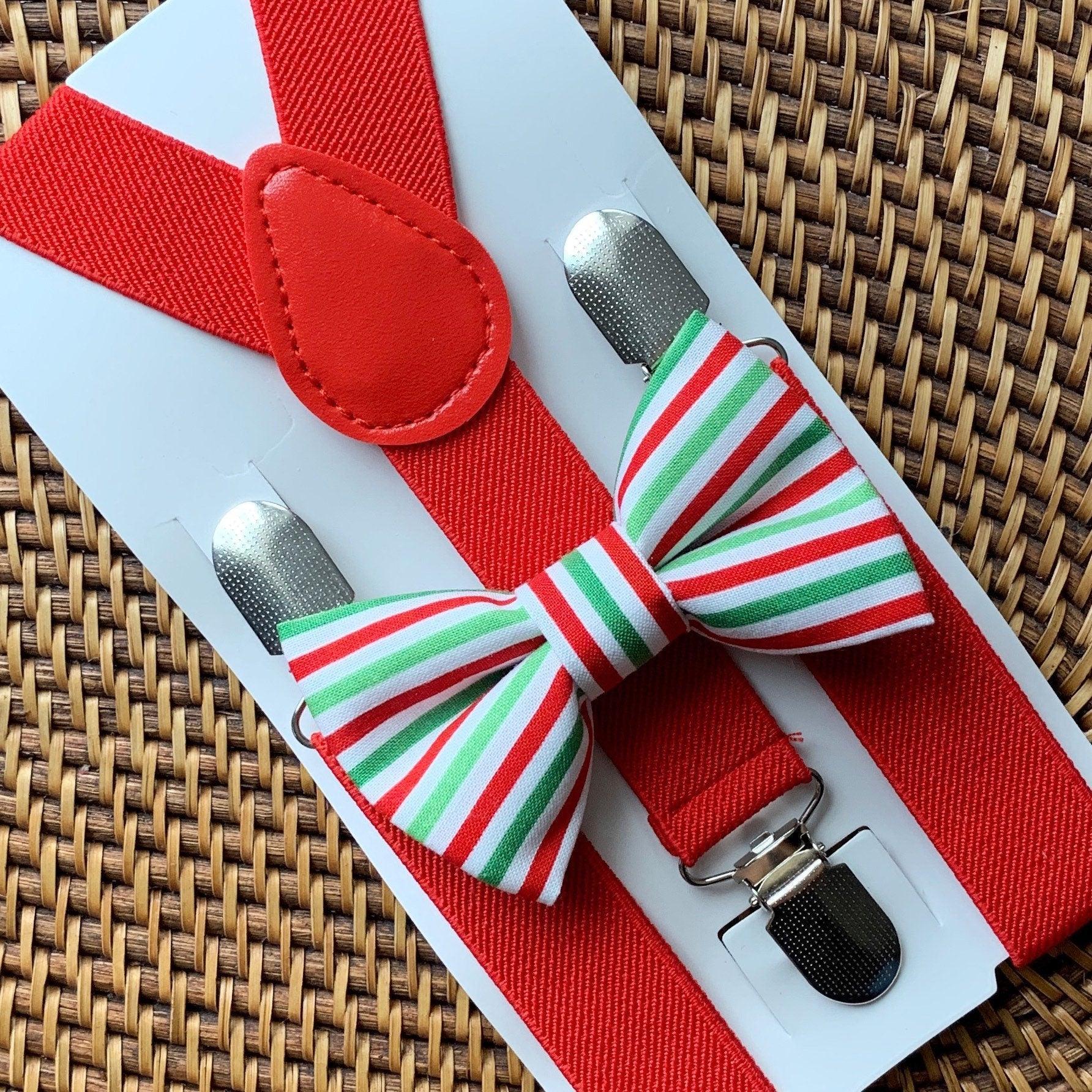 Red suspenders with a green white red striped bow tie on a white display card