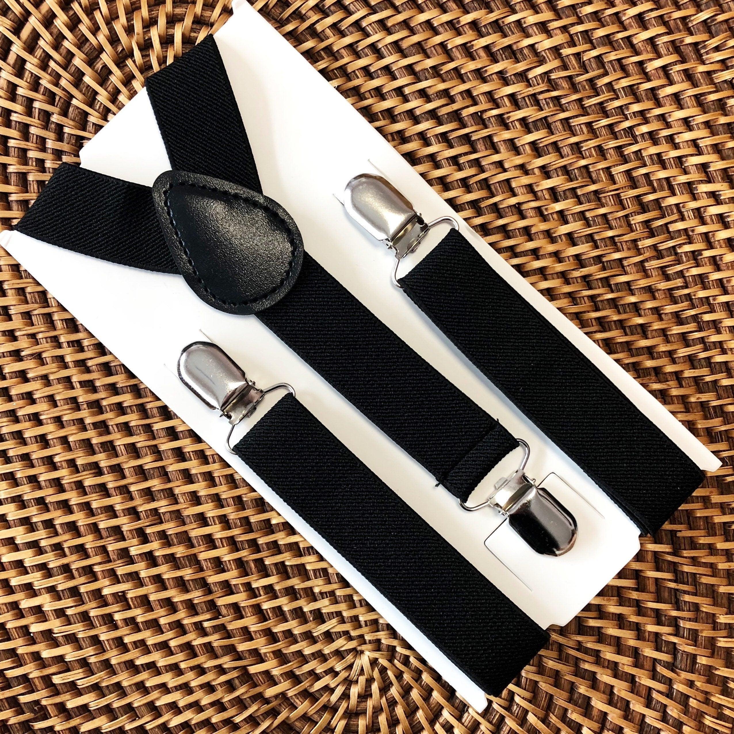 Close up of black elastic suspenders with silver clips on a white display card.