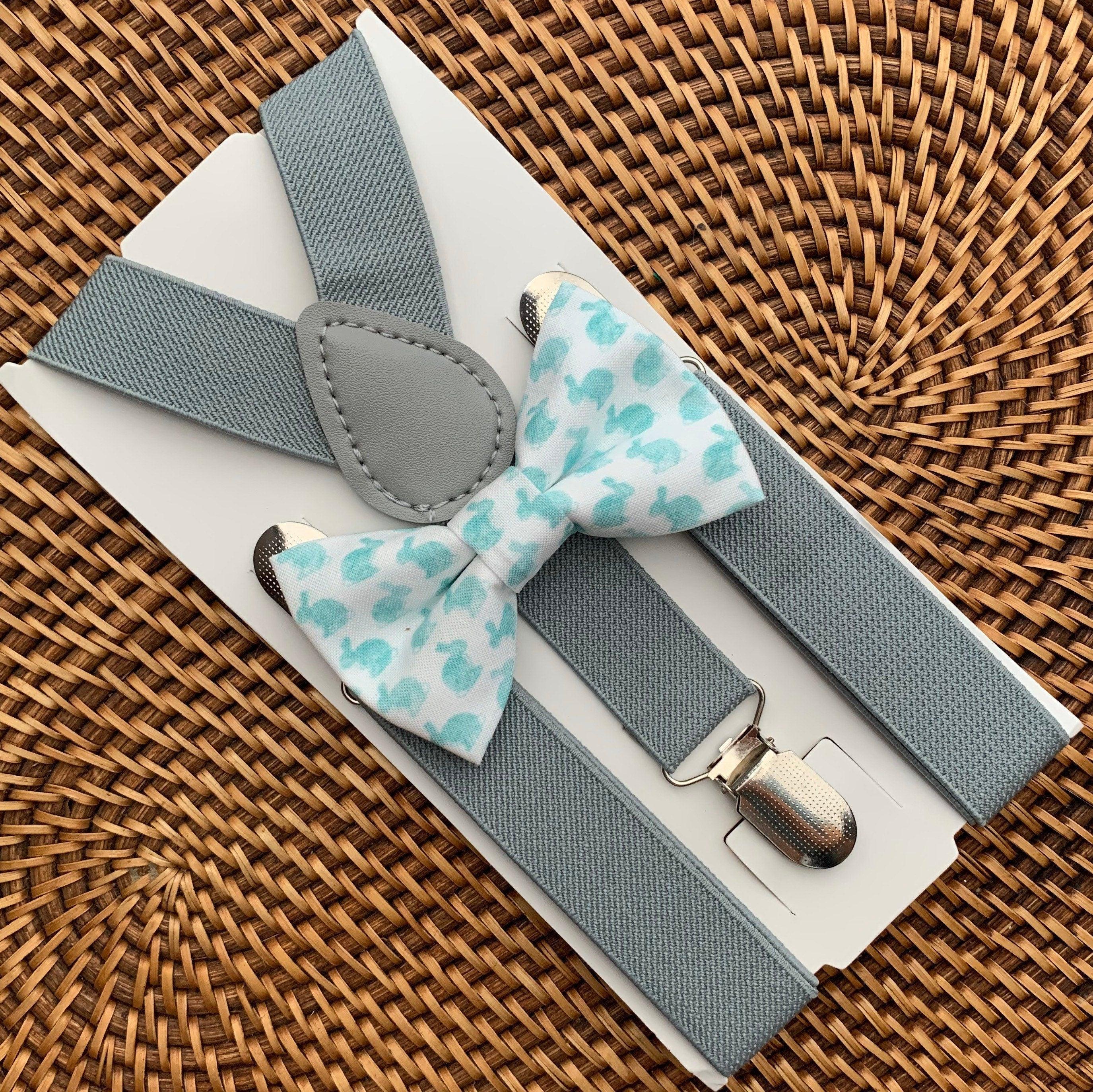 Blue watercolor Easter bunny bow tie with light grey suspenders displayed on a white card over a woven surface