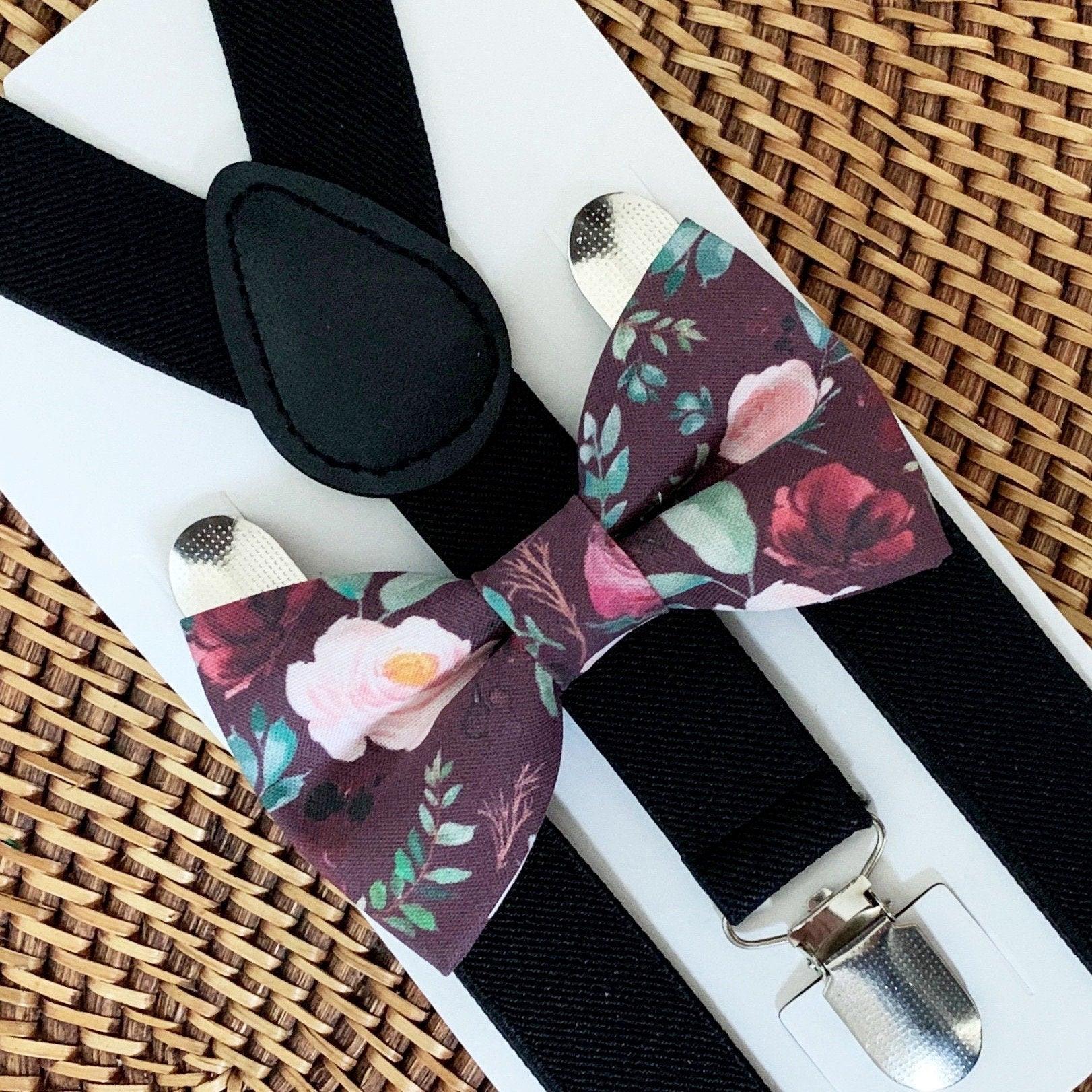 Maroon floral bow tie with black suspenders displayed on a white card