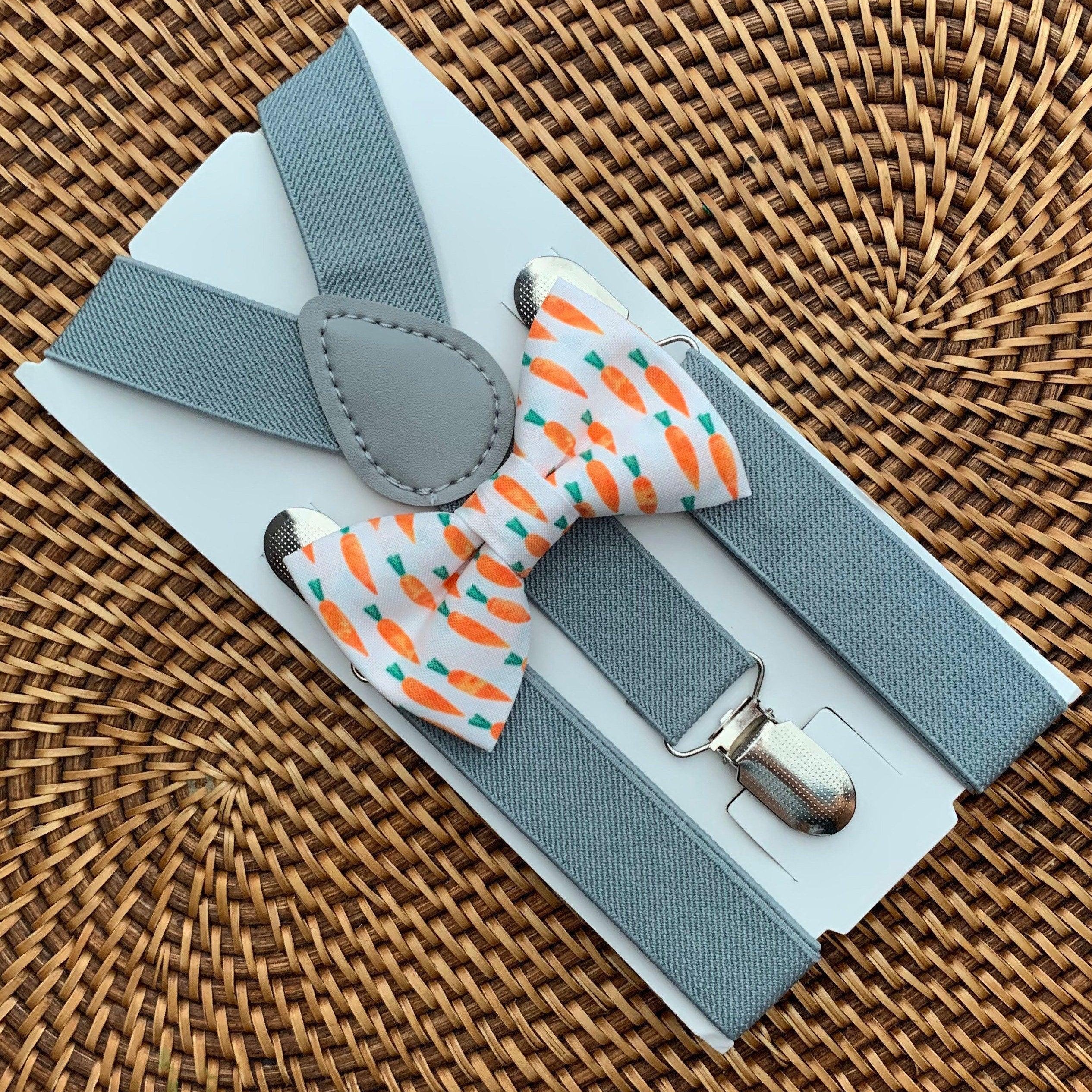 Close up of Easter carrot patterned bow tie and light gray suspenders on a white display card.
