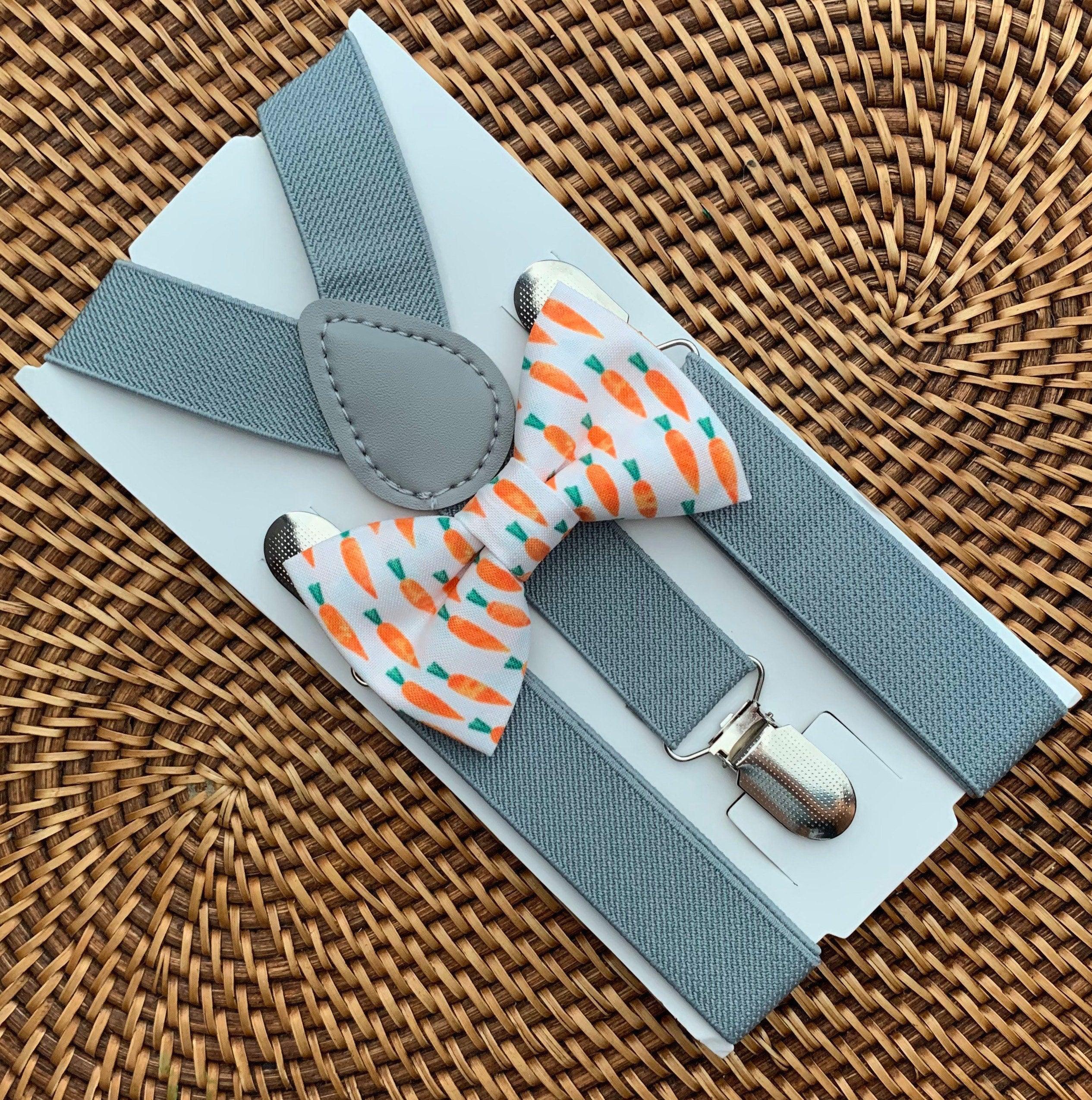 Close up of Easter carrot patterned bow tie and light gray suspenders on a white display card.