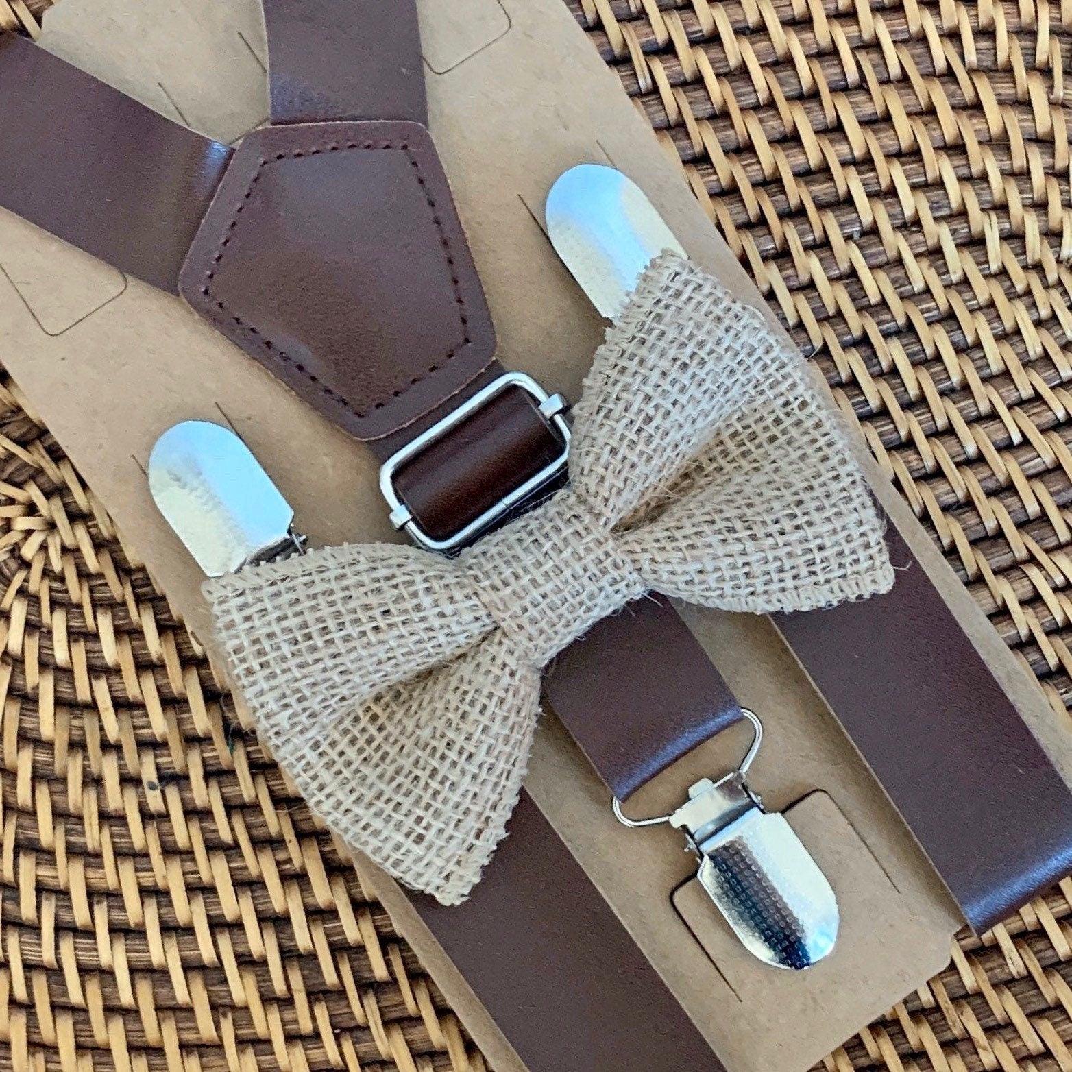 Brown suspenders with burlap bow ties on a woven surface