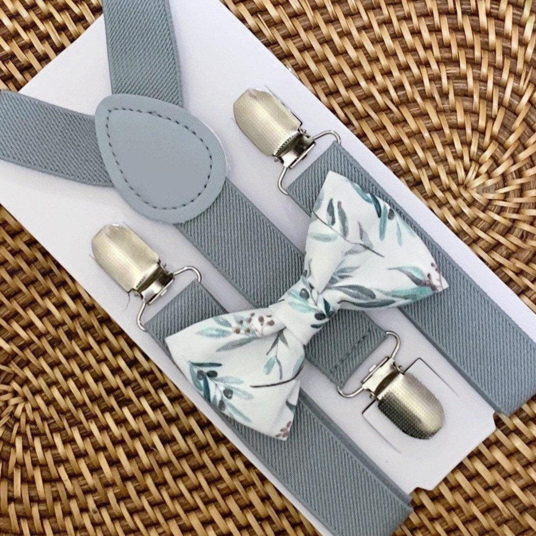 Close-up of sage floral bow tie paired with light gray suspenders on a white display card