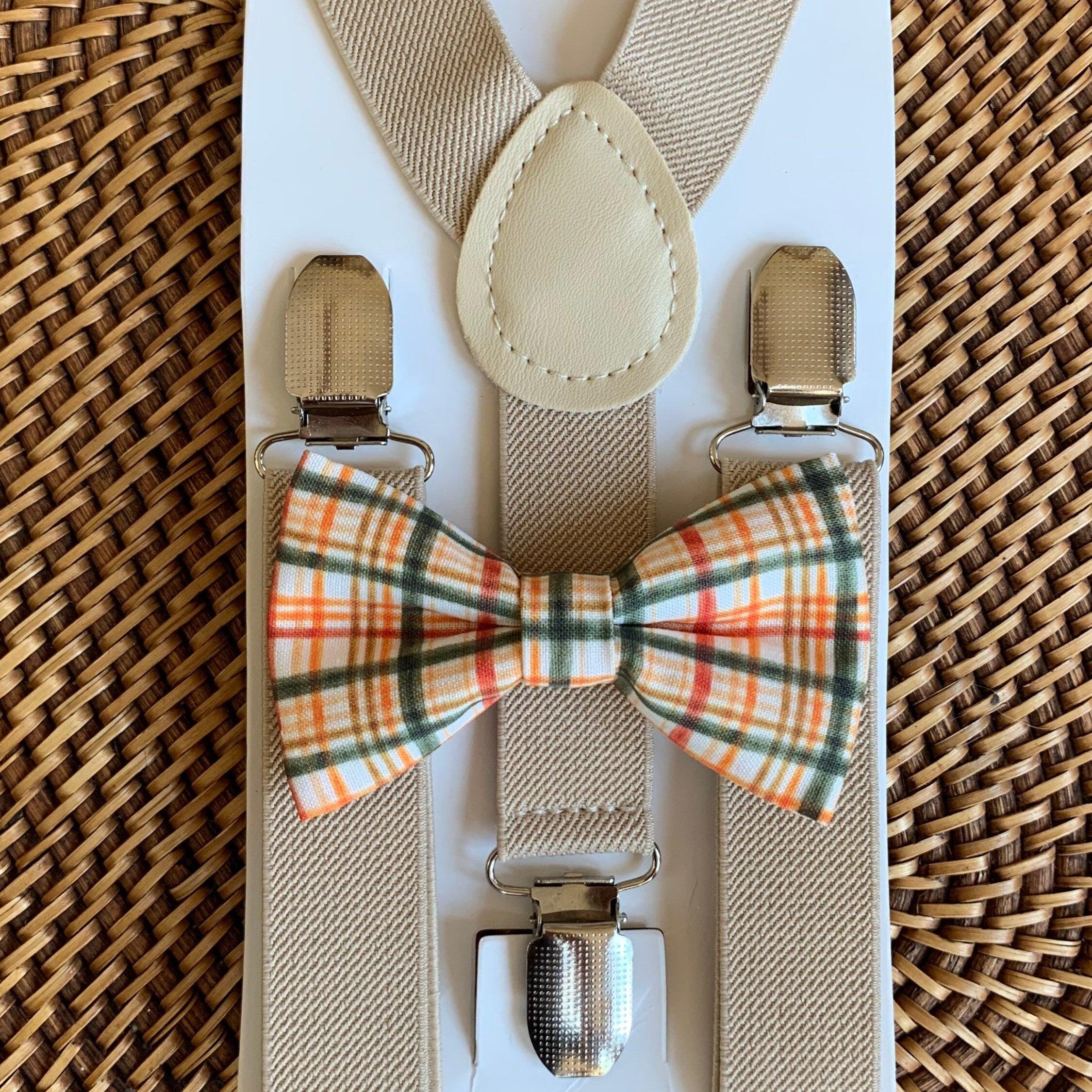 Orange plaid bow tie and tan suspenders.
