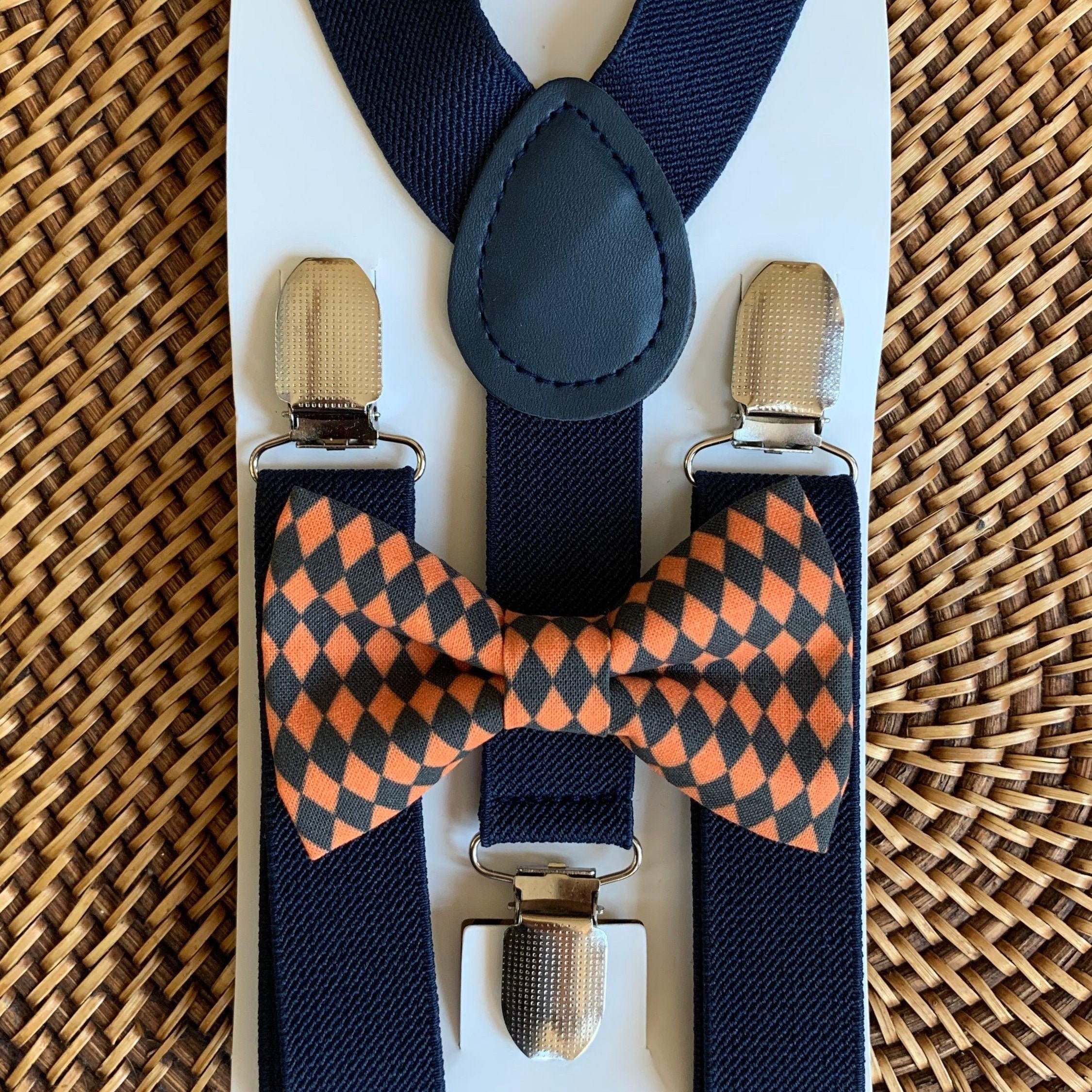Black and orange checkered bow tie and navy suspenders.