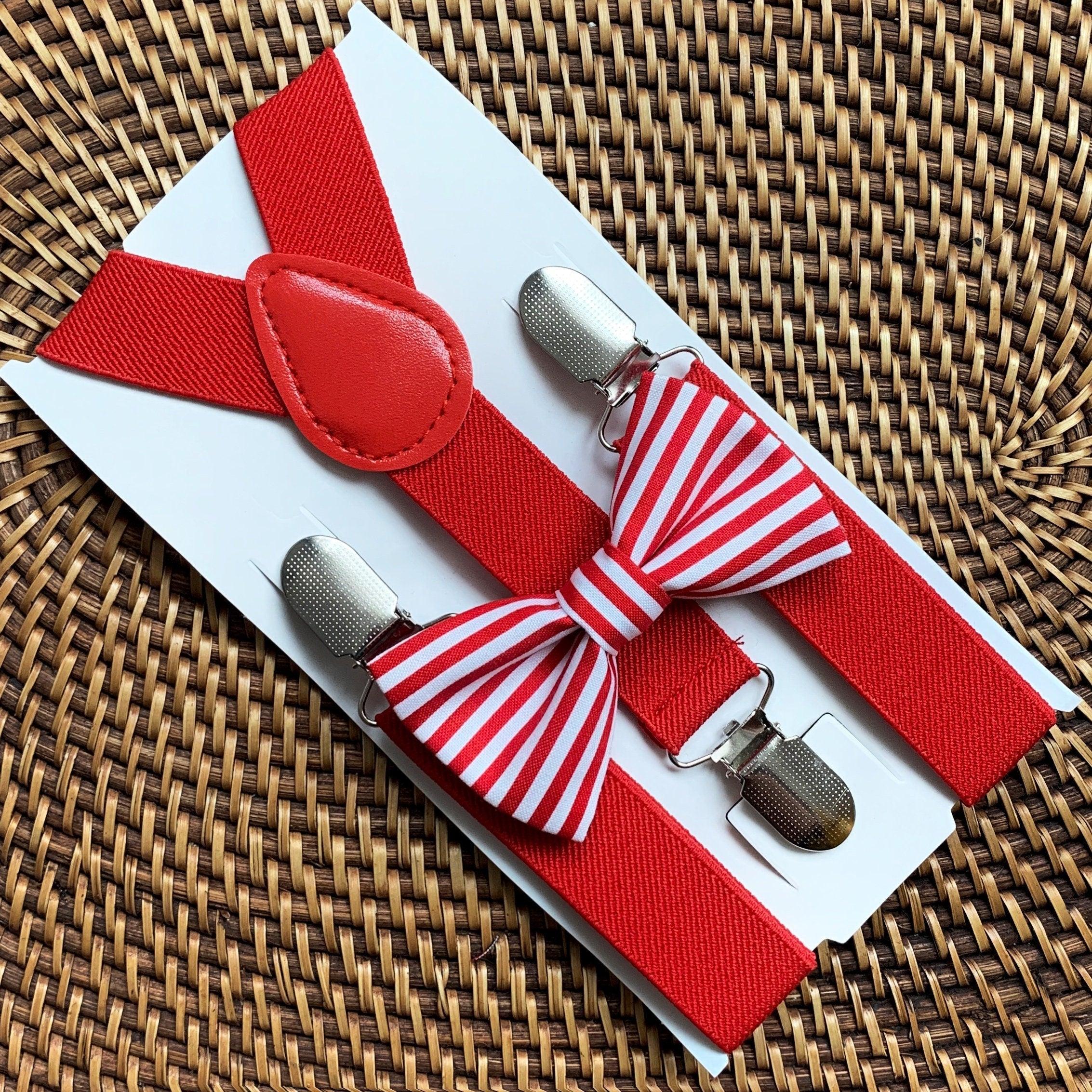 Red bow tie and red suspenders set displayed on a white card against a woven rattan background