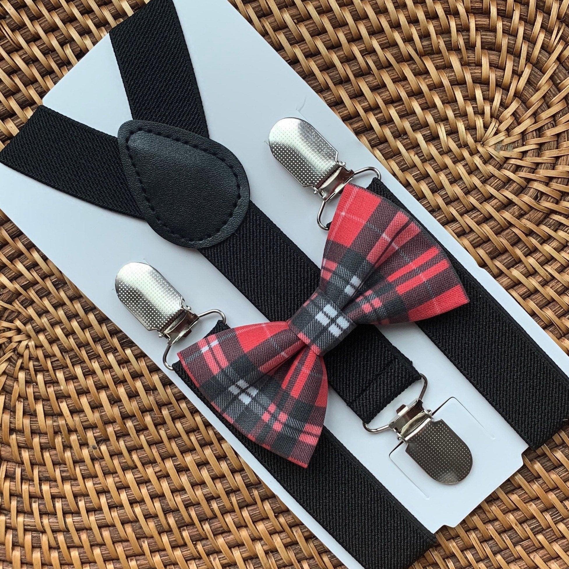 Black suspenders with Christmas red plaid bow tie on a white card, placed on a woven surface.
