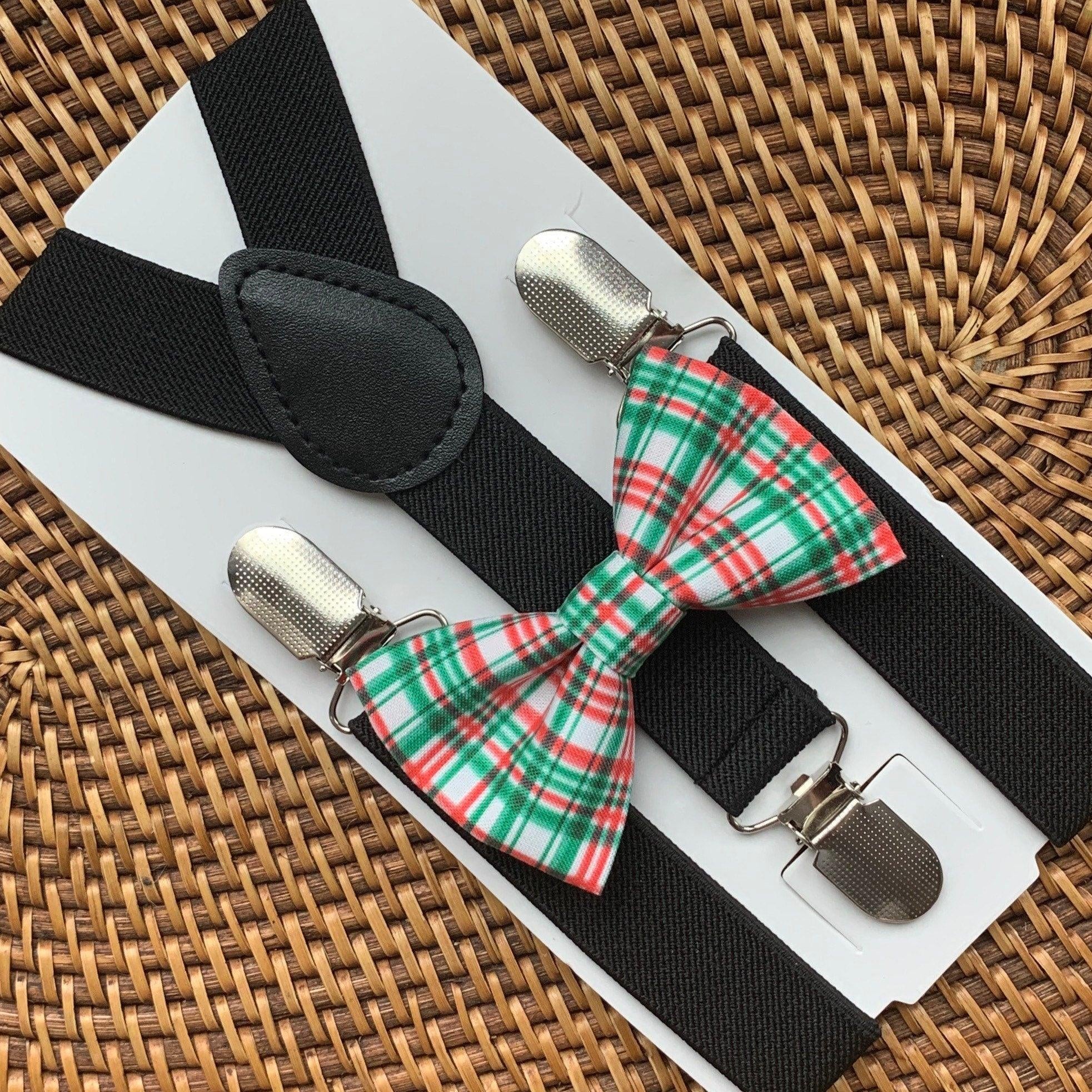 Close up of black suspenders with a red and green plaid bow tie on a light display board