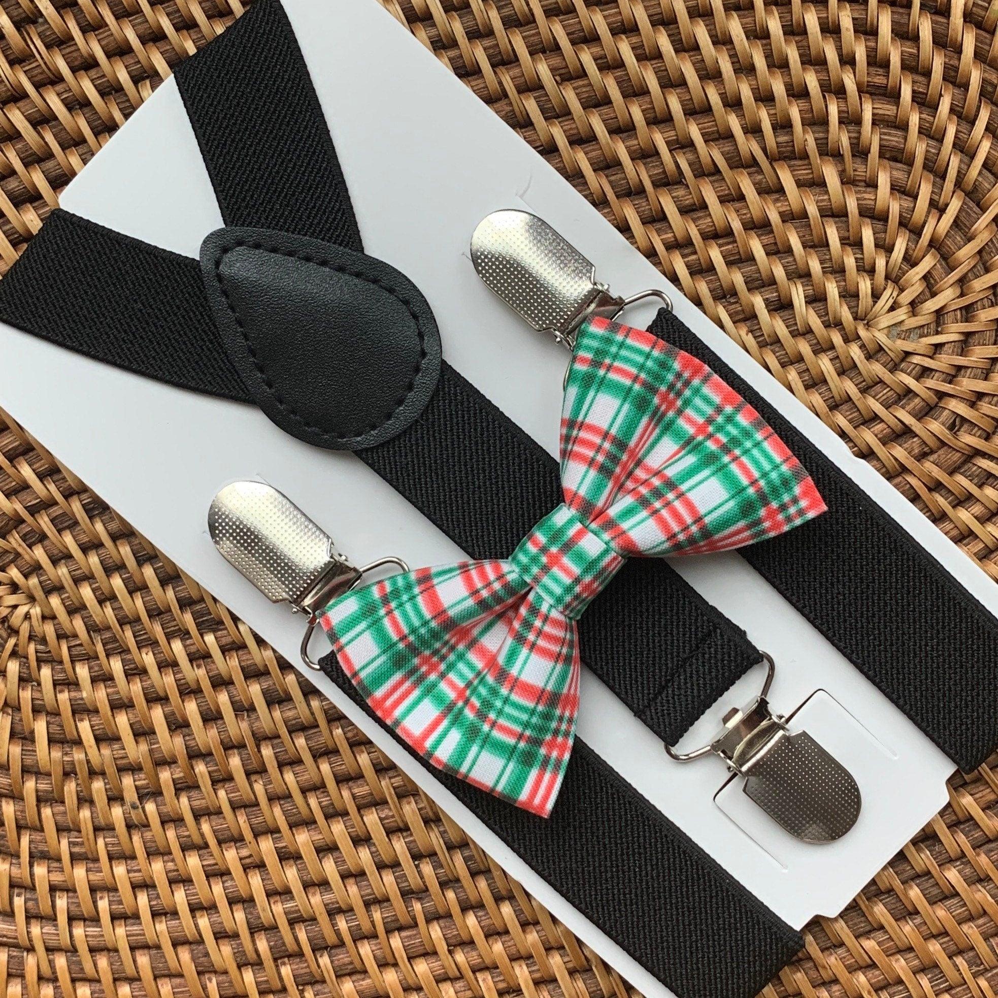 Close up of black suspenders with a red and green plaid bow tie on a light display board