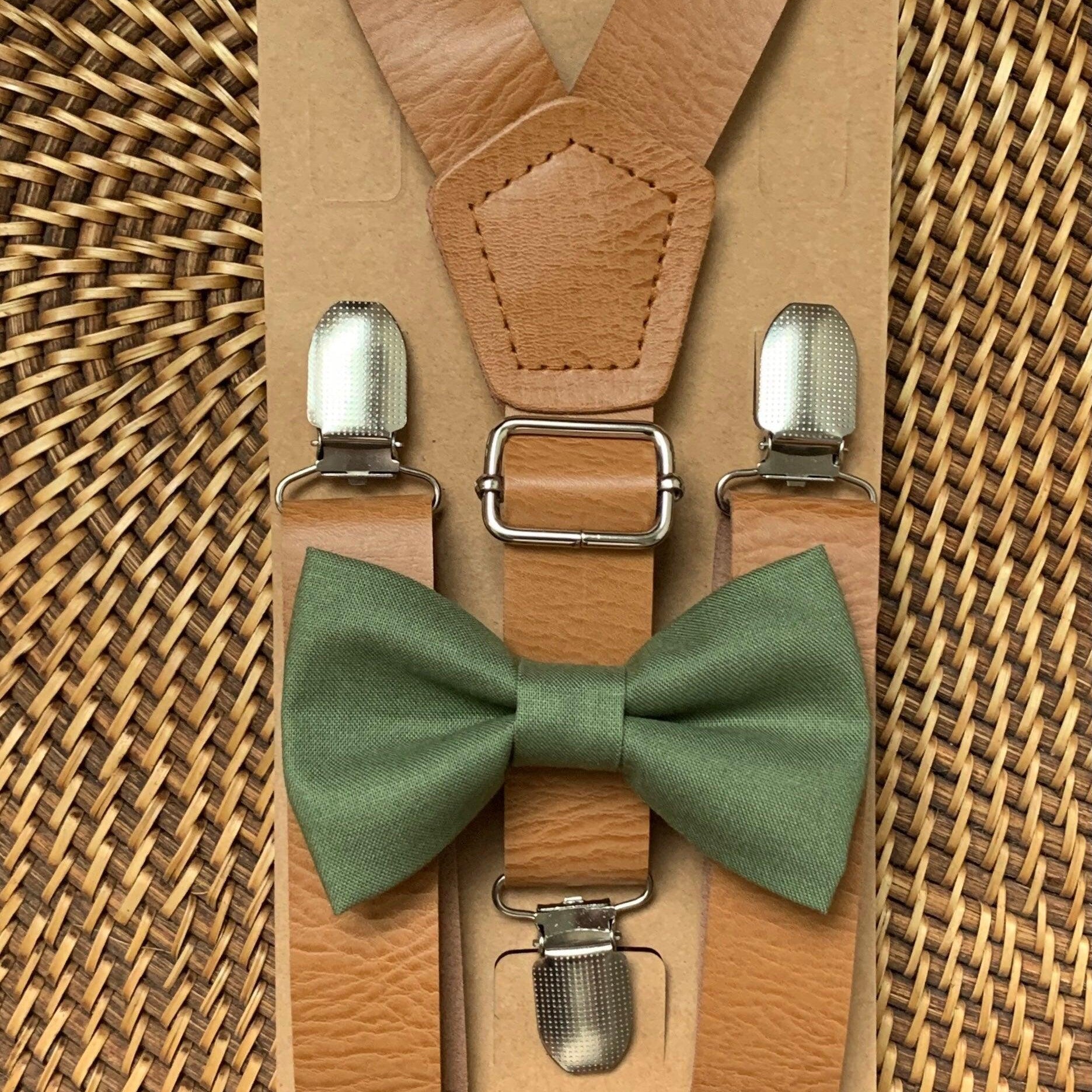 Close-up view of olive bow tie paired with tan vegan leather suspenders on brown kraft backing