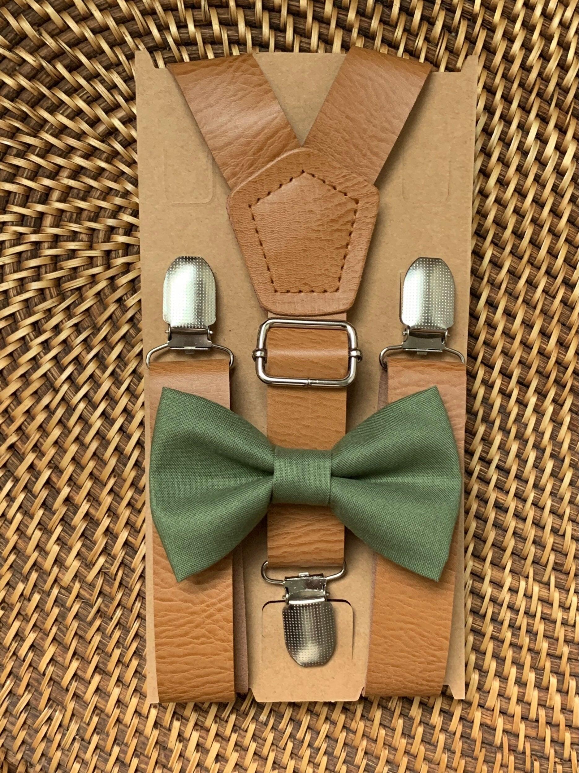 Close-up view of olive bow tie paired with tan vegan leather suspenders on brown kraft backing