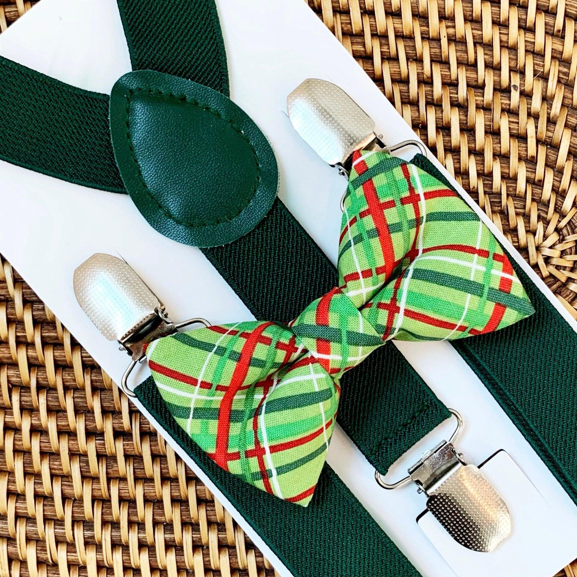 Green plaid bow tie and suspenders for Christmas on a brown woven background