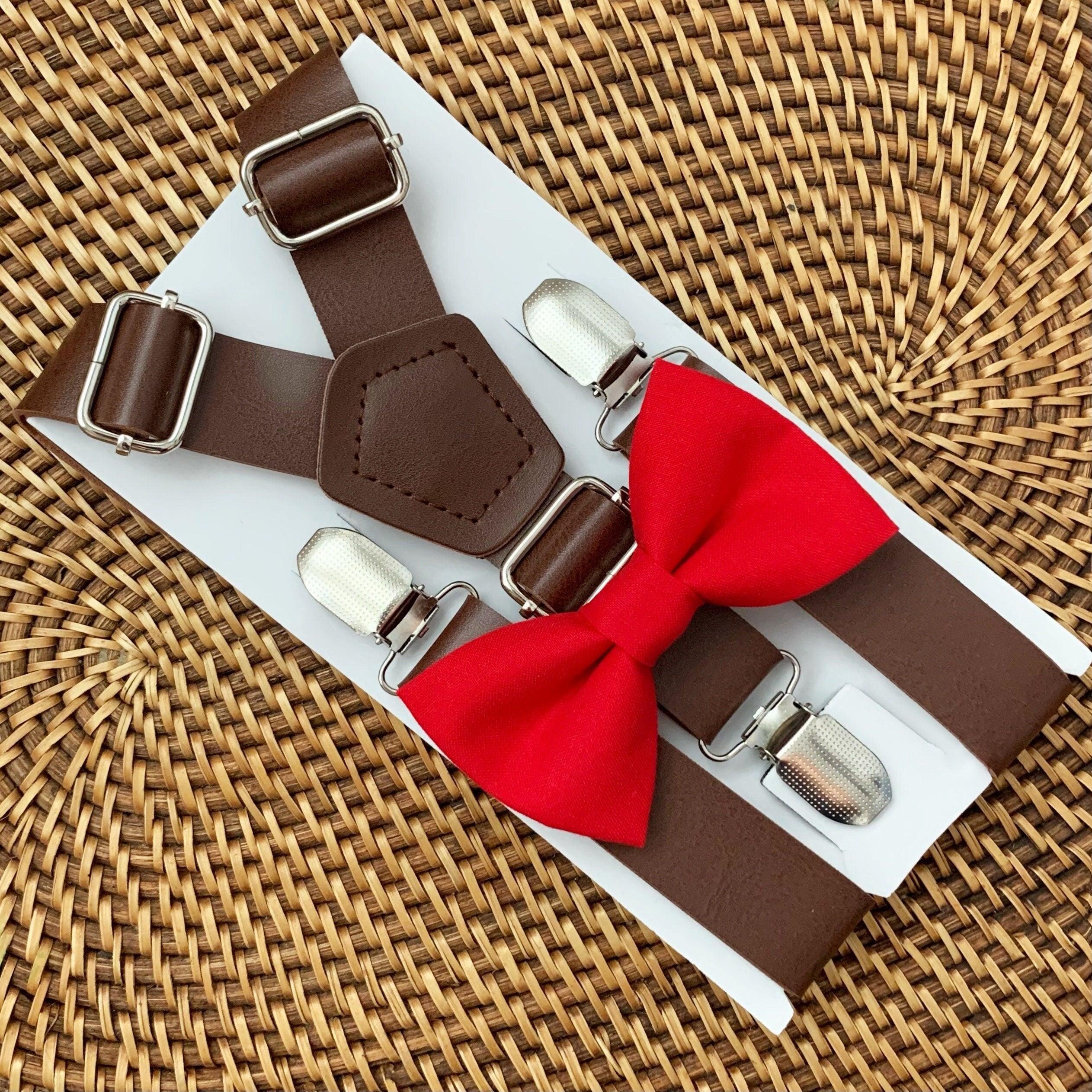 Brown suspenders with a red bow tie on a white background