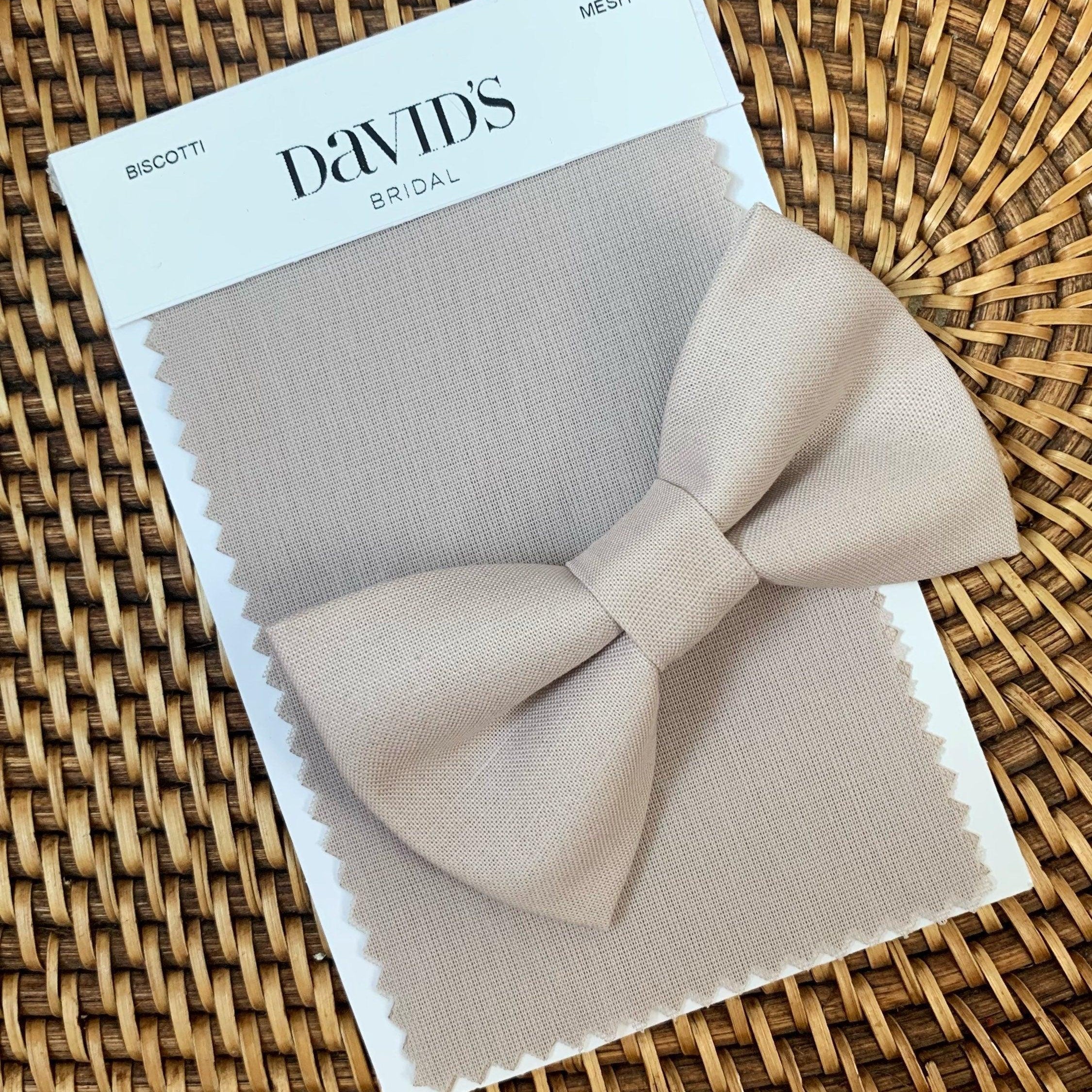 Beige Biscotti bow tie beige fabric bow against a wicker background