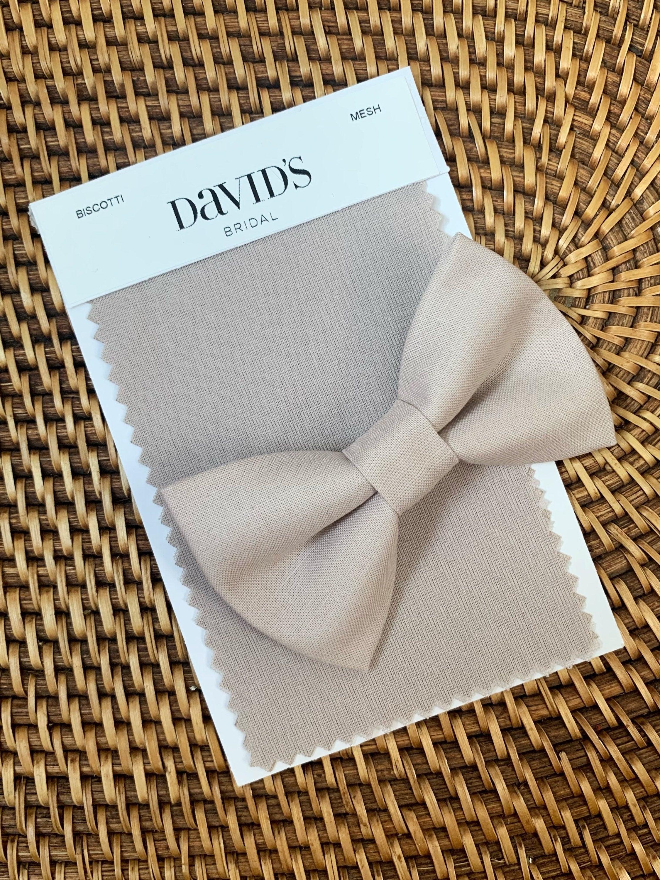 Beige Biscotti bow tie beige fabric bow against a wicker background