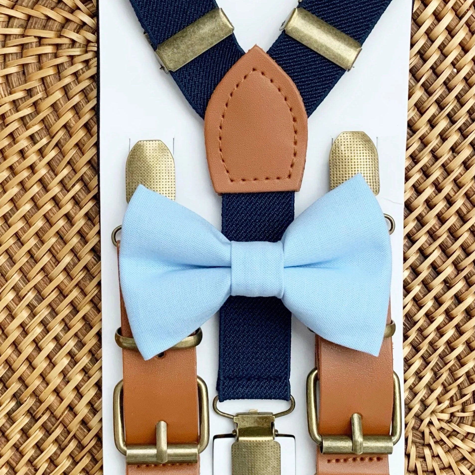 Size chart for suspender and bow tie sets from The Bold Bow Tie. X-Small (6mo-4yr): 15"-23" suspenders, 3.5" bow. Small (5-9yr): 18"-33" suspenders, 3.5" bow. Medium (10-12yr): 18"-33" suspenders, 4" bow. Adult (13yr-6'5"): 30"-53" suspenders, 4.5" bow. Big & Tall (Over 6'5"): 53"+ suspenders, 4.5" bow. Instructions note to measure from the back waistband over the shoulder to the front waistband for a comfortable fit.