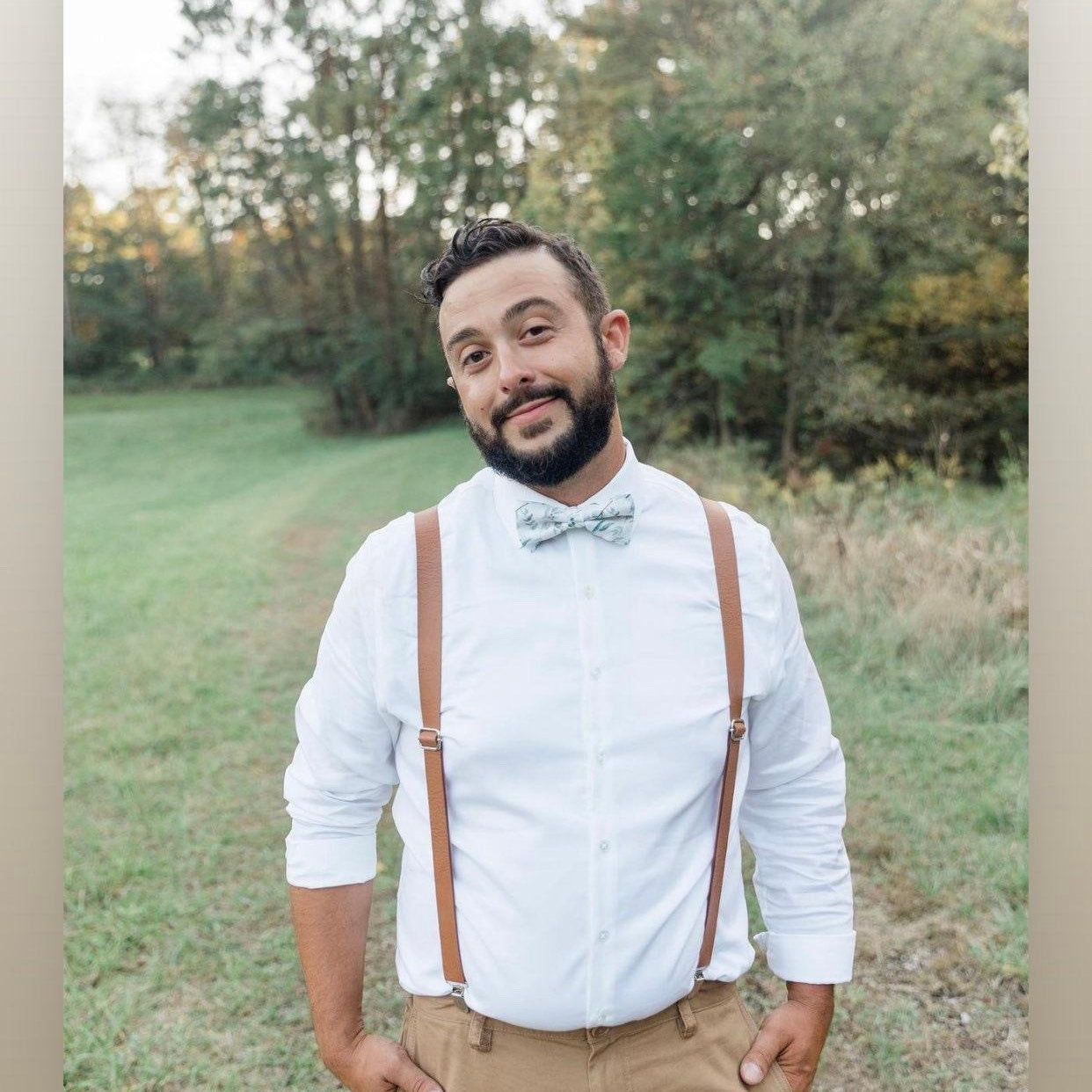 Groom waiting for his bride in brown vegan leather suspenders and sage floral bow tie.