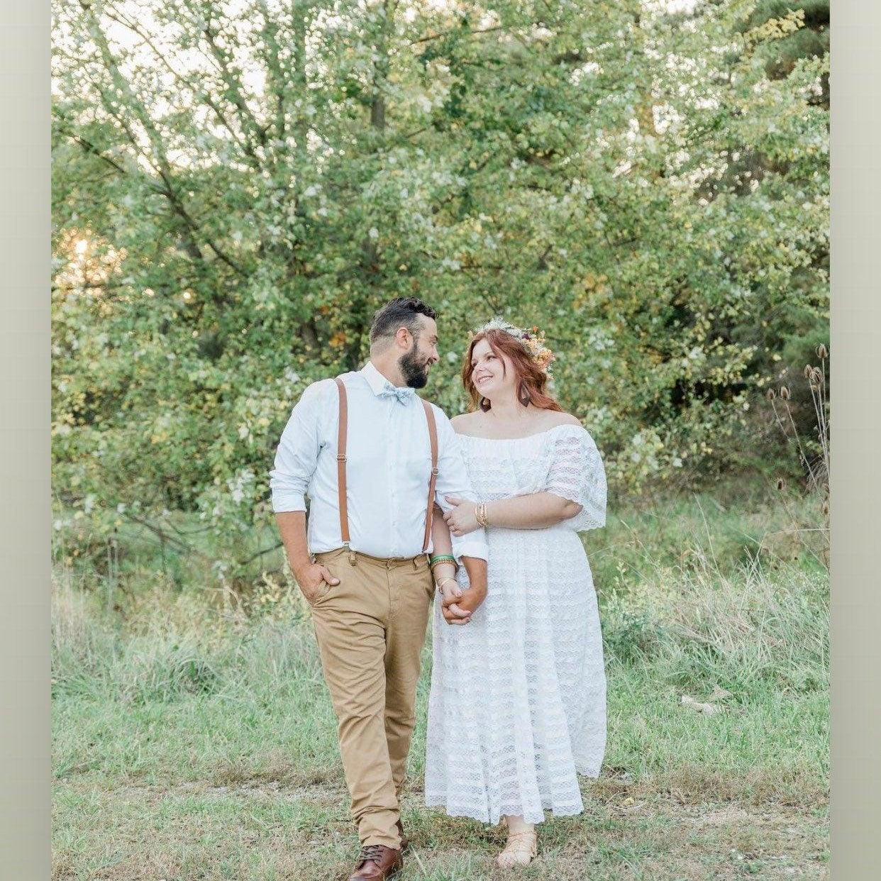 Bride & Groom at their wedding with the groom wearing brown vegan leather suspenders and sage floral bow tie