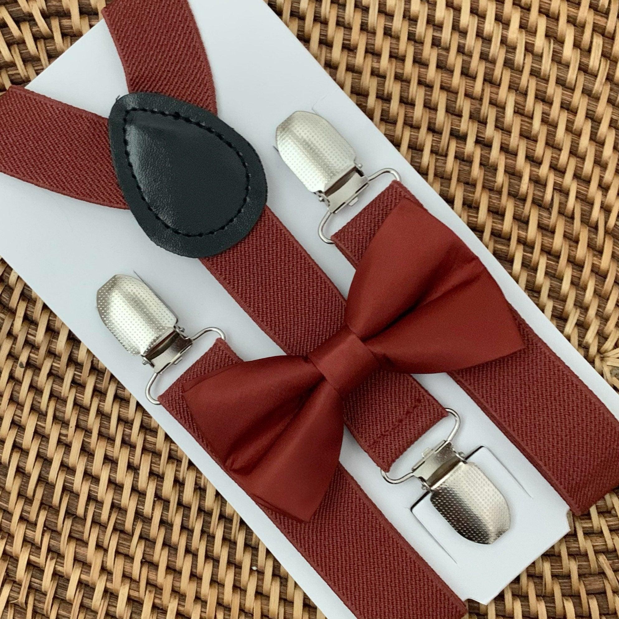 A set of cinnamon red orange suspenders and a bow tie on a white background, likely made of satin material.