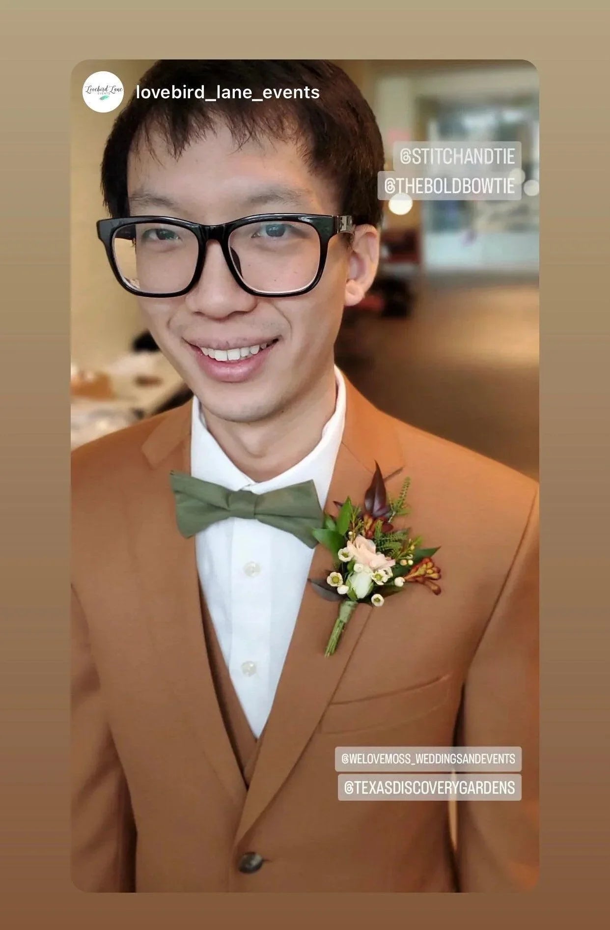 Close up of a man in a tan suit wearing an olive bow tie and floral boutonniere