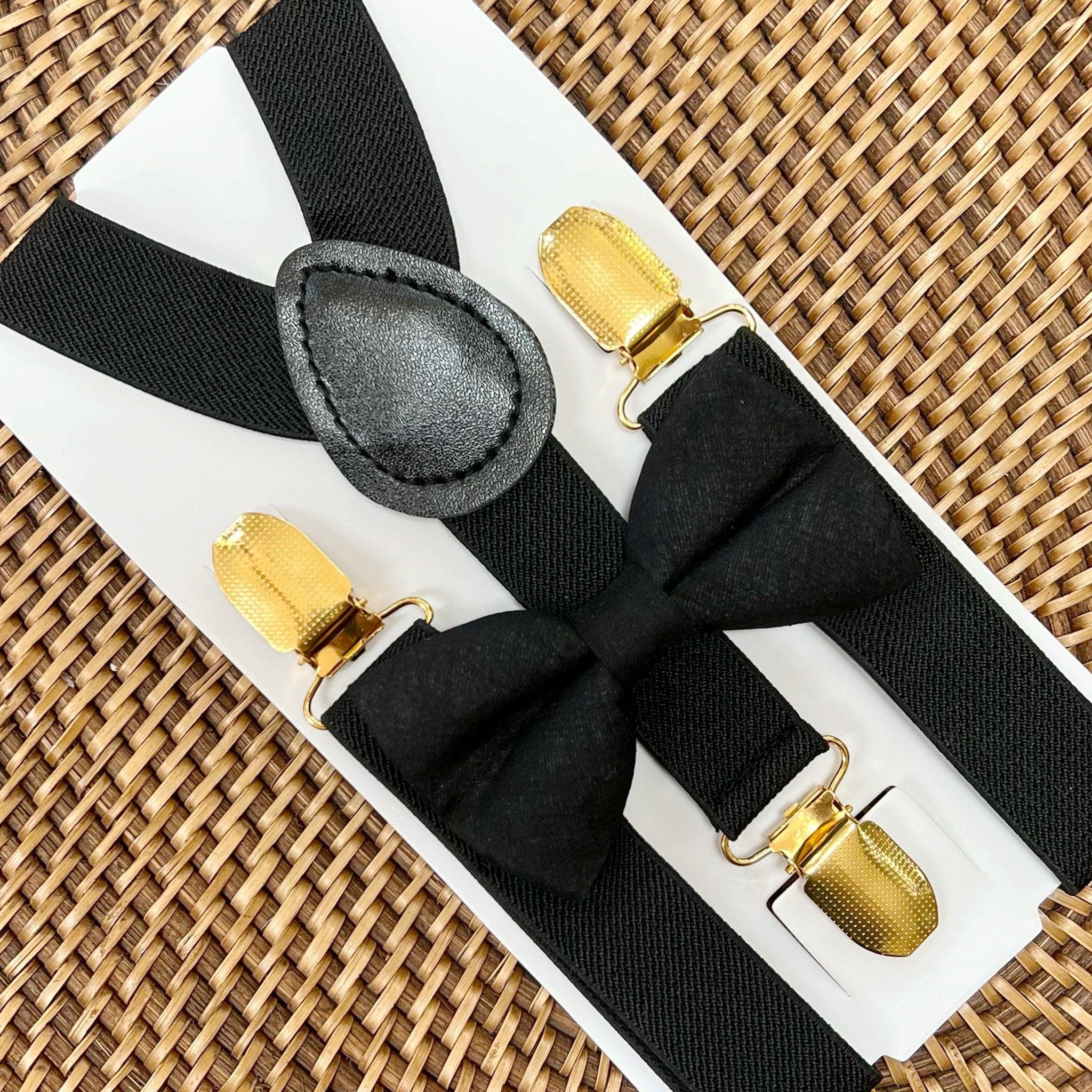Black bow tie and black suspenders with gold clips for wedding, ring bearer outfit or groomsmen in a wedding party.