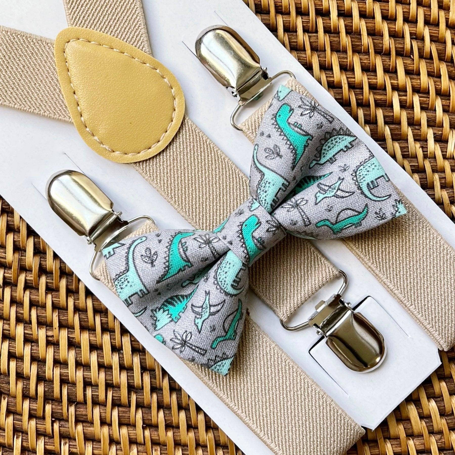 Bow tie and suspenders set with dinosaur pattern on a woven surface