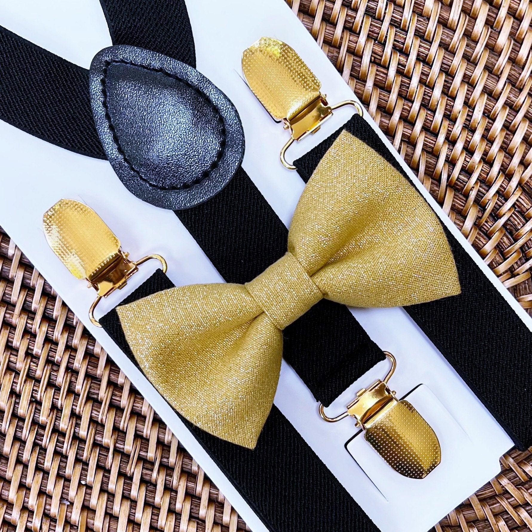 Gold bow tie and suspenders displayed on a white card