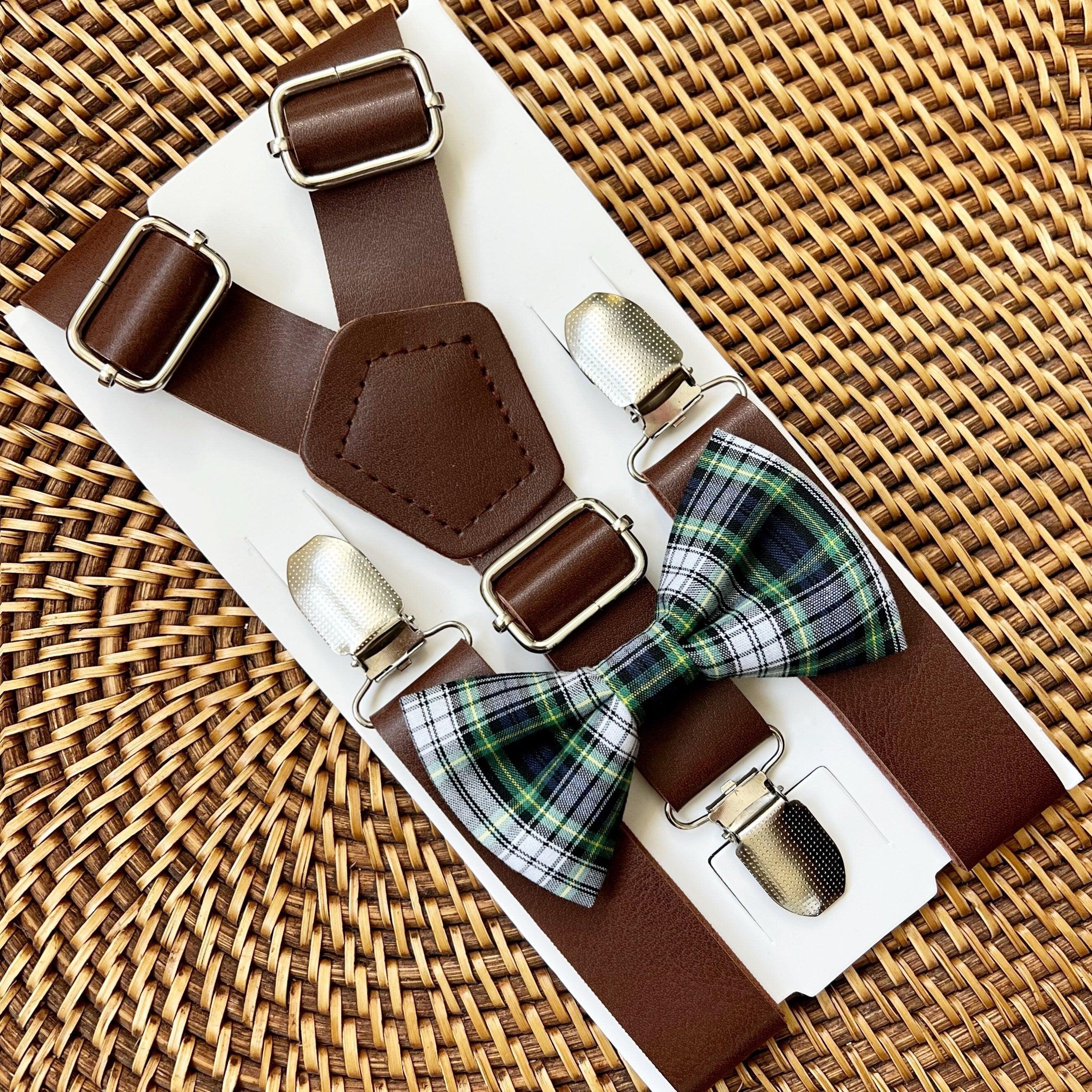 Navy green and white tartan bow tie with dark brown vegan leather suspenders displayed on a white card