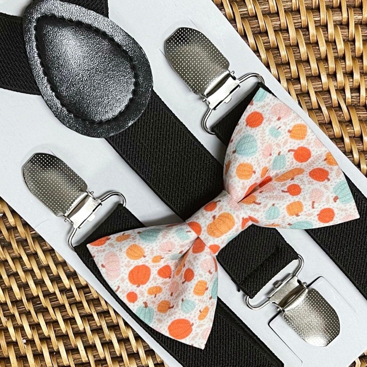 Pumpkin orange and teal polka dot bow ties paired with black suspenders on a display card