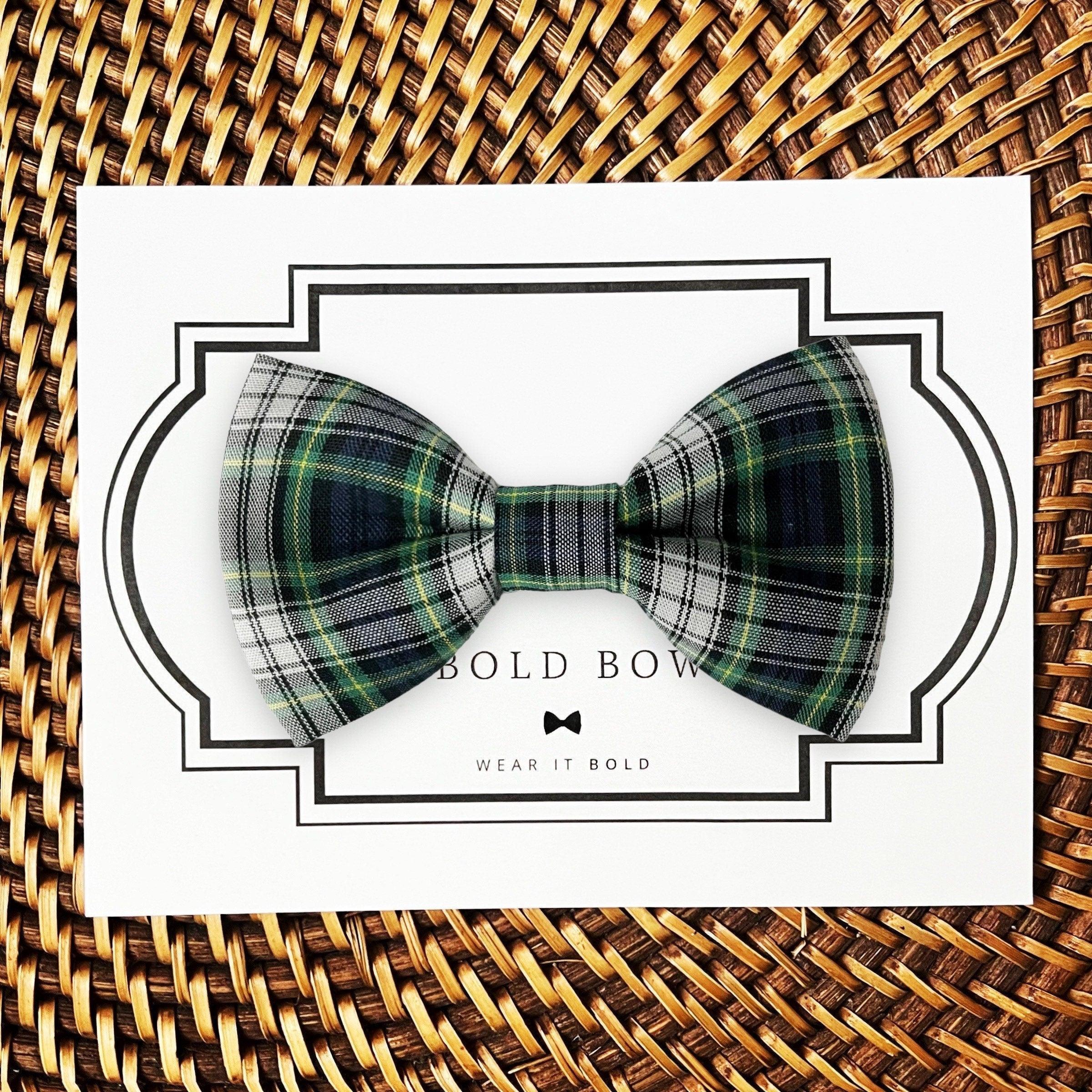 Product graphic showcasing the back of a pre-tied bow tie in a red and black buffalo plaid pattern, resting on a rustic wood surface. Two black elastic loops are attached to the center knot to slide onto a pet collar. Overlay text reads: Back of Bow Tie (may not be actual bow tie in listing).