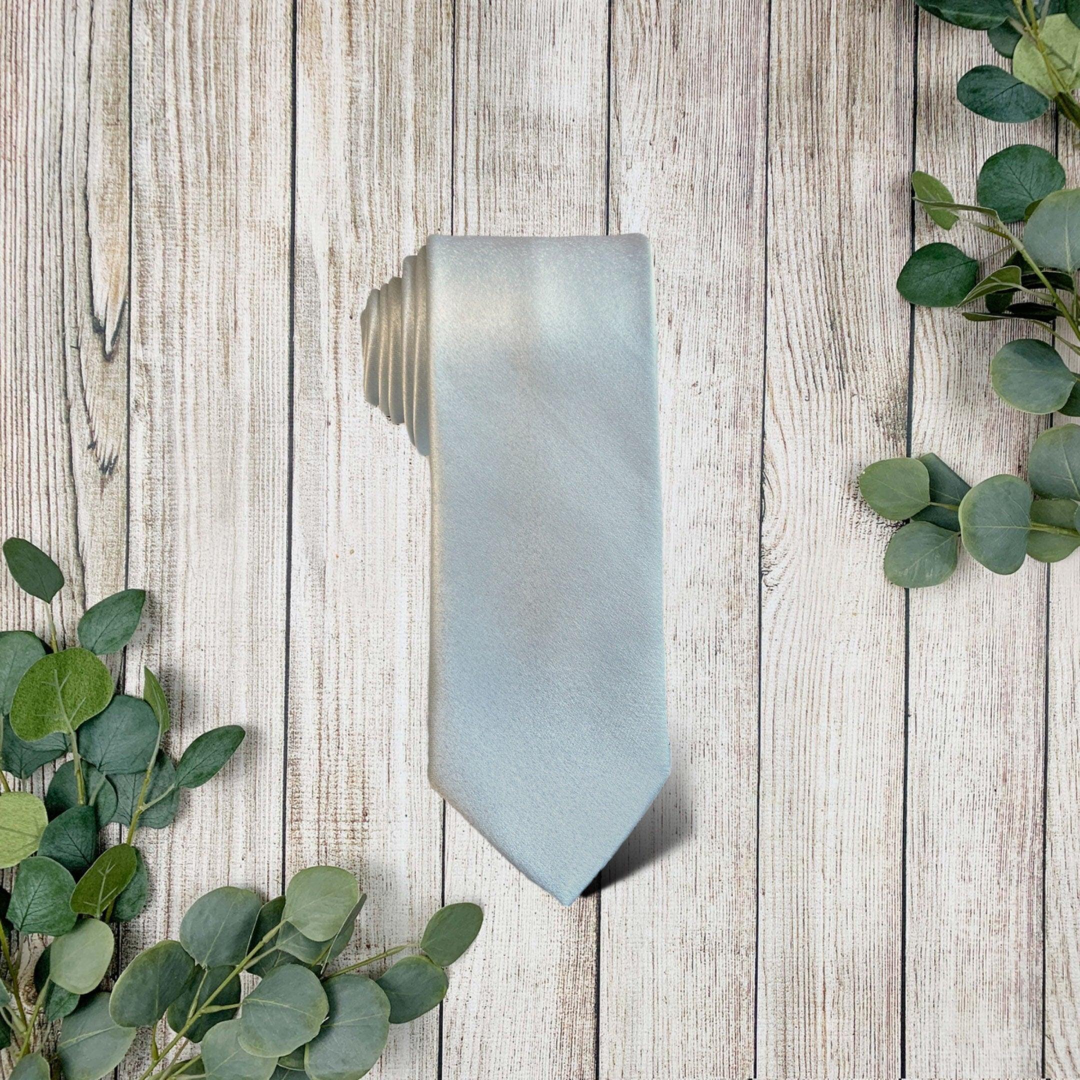 Cinderella blue necktie on a weathered wooden surface with eucalyptus leaves