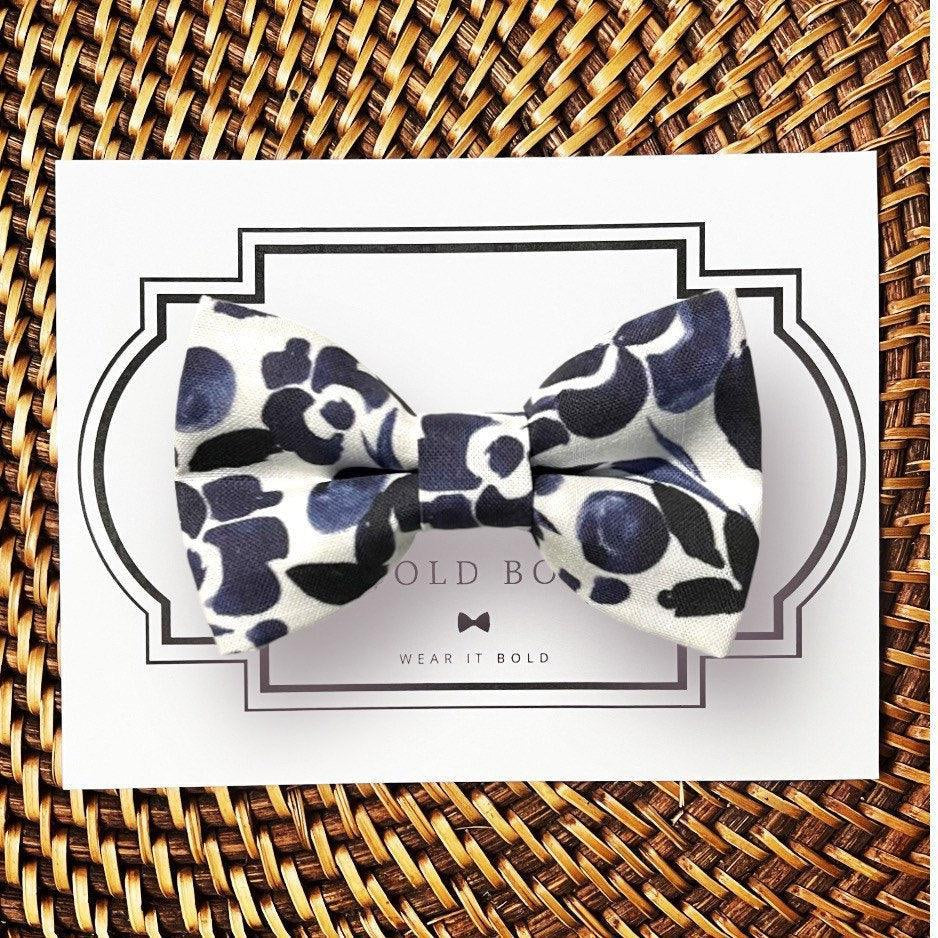 Dog bow tie size chart. Size Small is 3 1/2 inches wide for small dogs under 15 lbs. Size Medium is 4 inches wide for medium dogs between 15 band 40 lbs. Size Large is 4 1/2 inches wide for Large Dogs between 40 band 80 lbs. Size Extra Large is 5 1/2 inches wide for Extra Large Dogs over 80 lbs. Sizing is up to preference and pet bow ties slide on to dog collars with elastic.