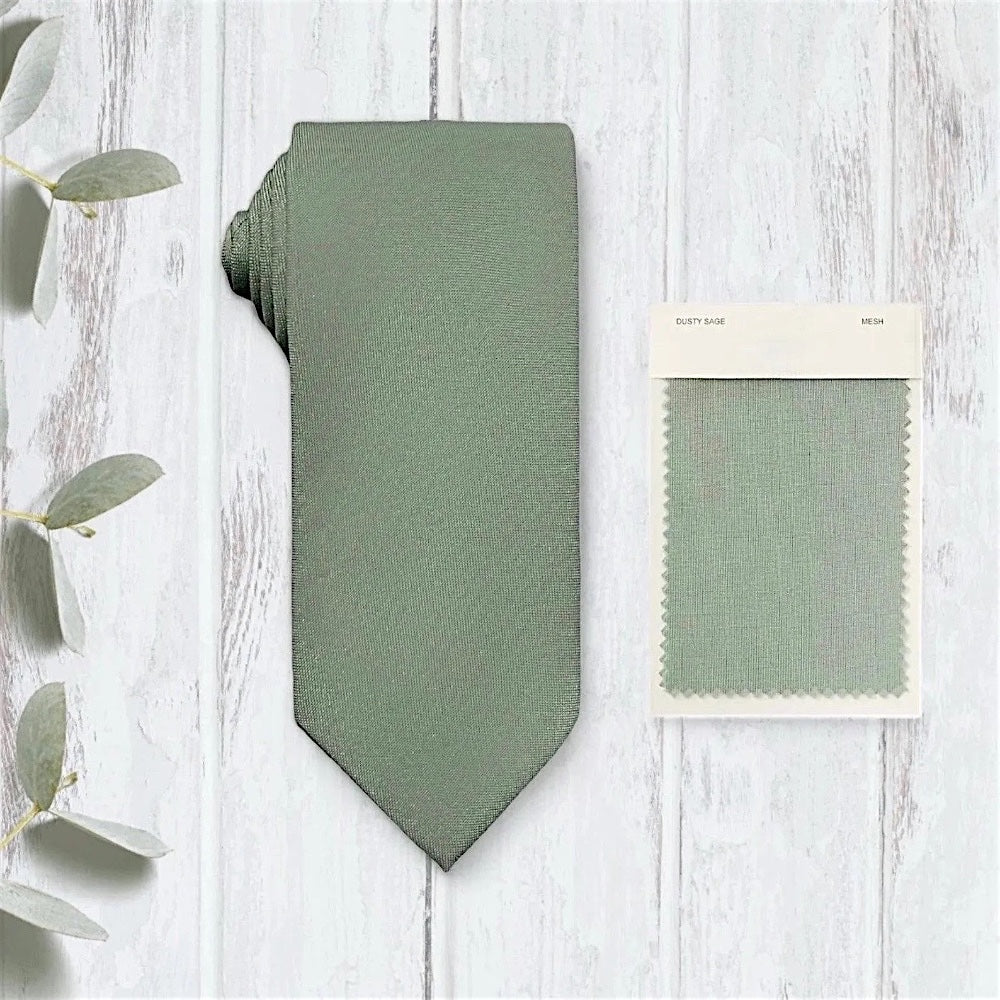 Sage green tie for men on wooden table.
