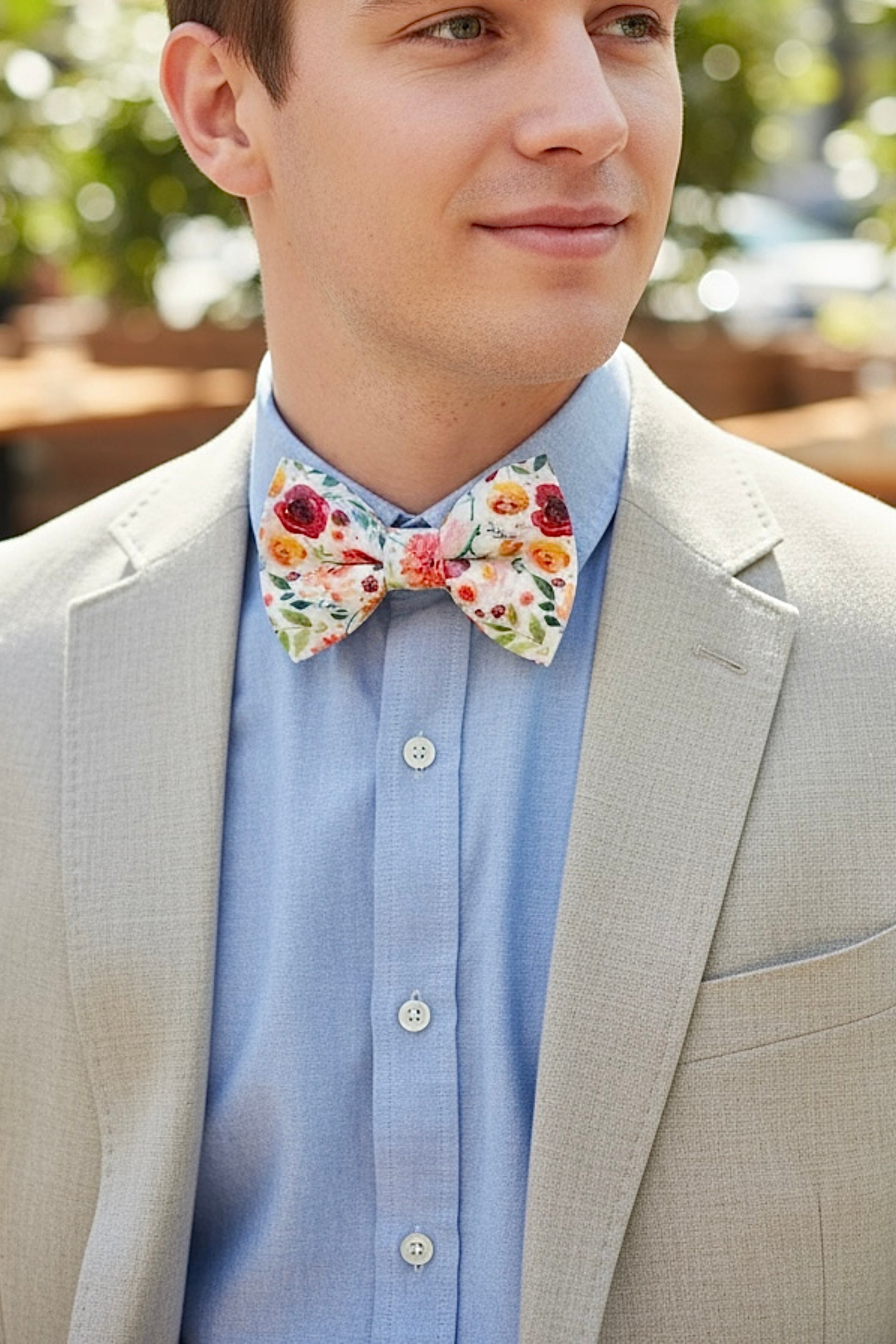 Groomsman in a wildflower floral bow tie getting ready for a wedding.