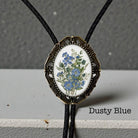 Dusty Blue floral bolo tie with bronze vintage frame and braided leather cord for groom and groomsmen rustic wedding attire.