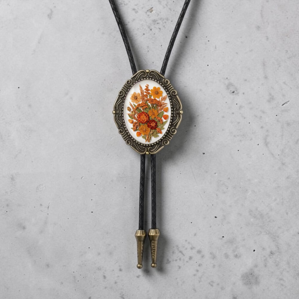 A decorative pendant featuring a floral design is hanging from a black cord against a gray background.