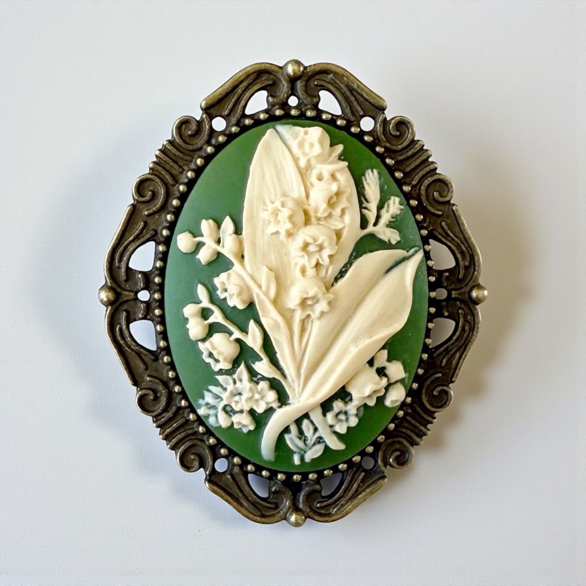Decorative Vintage Style May Flower Green Lily of the Valley brooch with floral design.