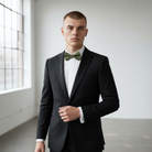 Groomsman in an olive green bow tie in a wedding party.